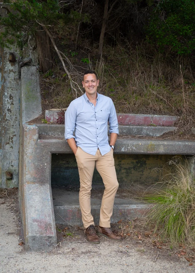 Man standing by a stone bench in an outdoor setting