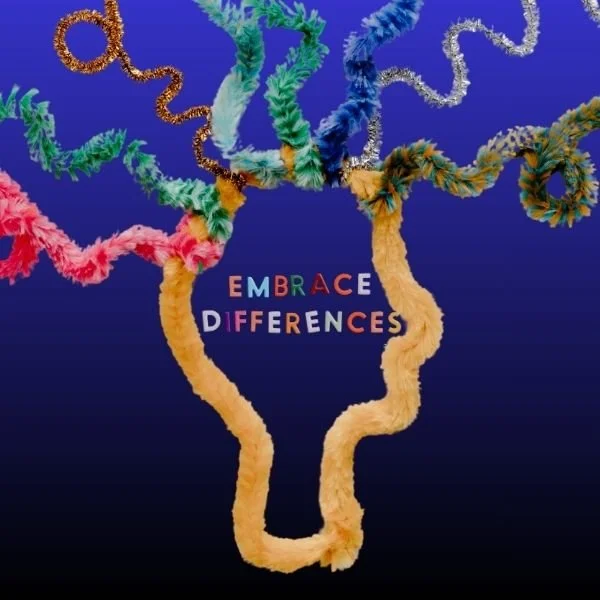 Colorful tissue paper flowers arranged to spell out "Embrace Differences" on a blue background.