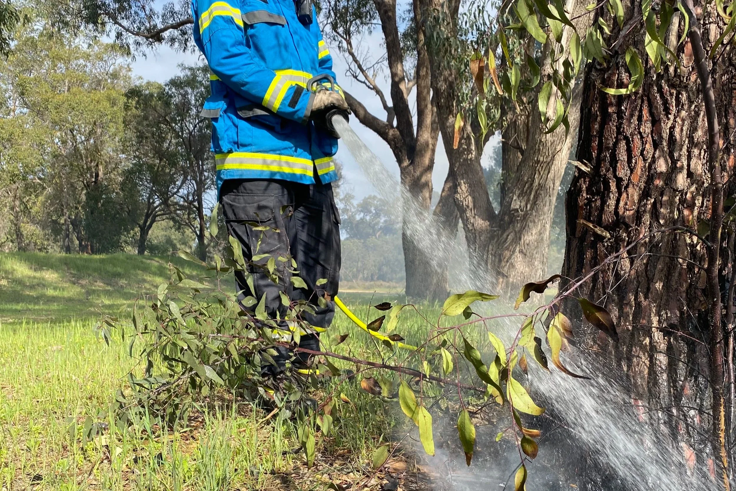 Firefighter mopping up from a hazard reduction burn