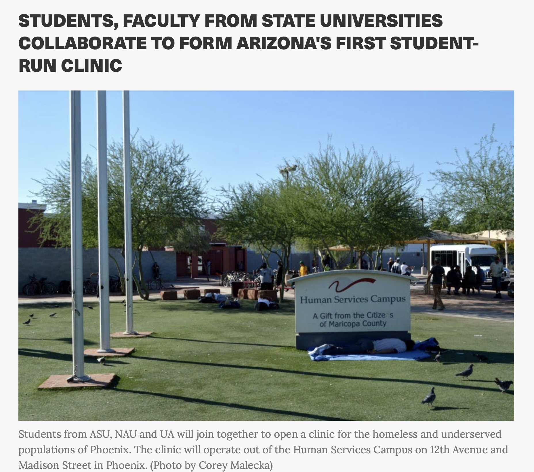 A photograph showing a park-like setting with a sign that reads "Human Services Campus, A Gift from the Citize..." with trees, birds, and people gathered around, and a clear blue sky in the background.