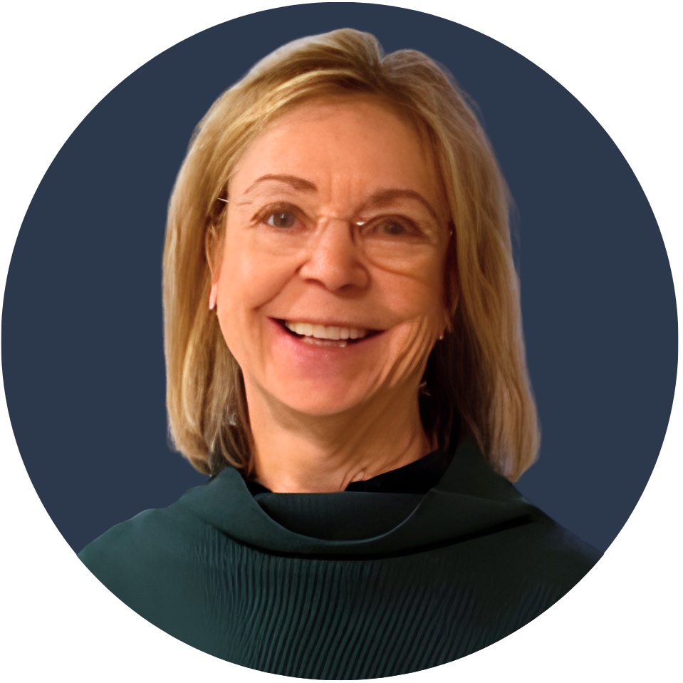 A smiling woman with shoulder-length blonde hair wearing glasses and a dark green top.