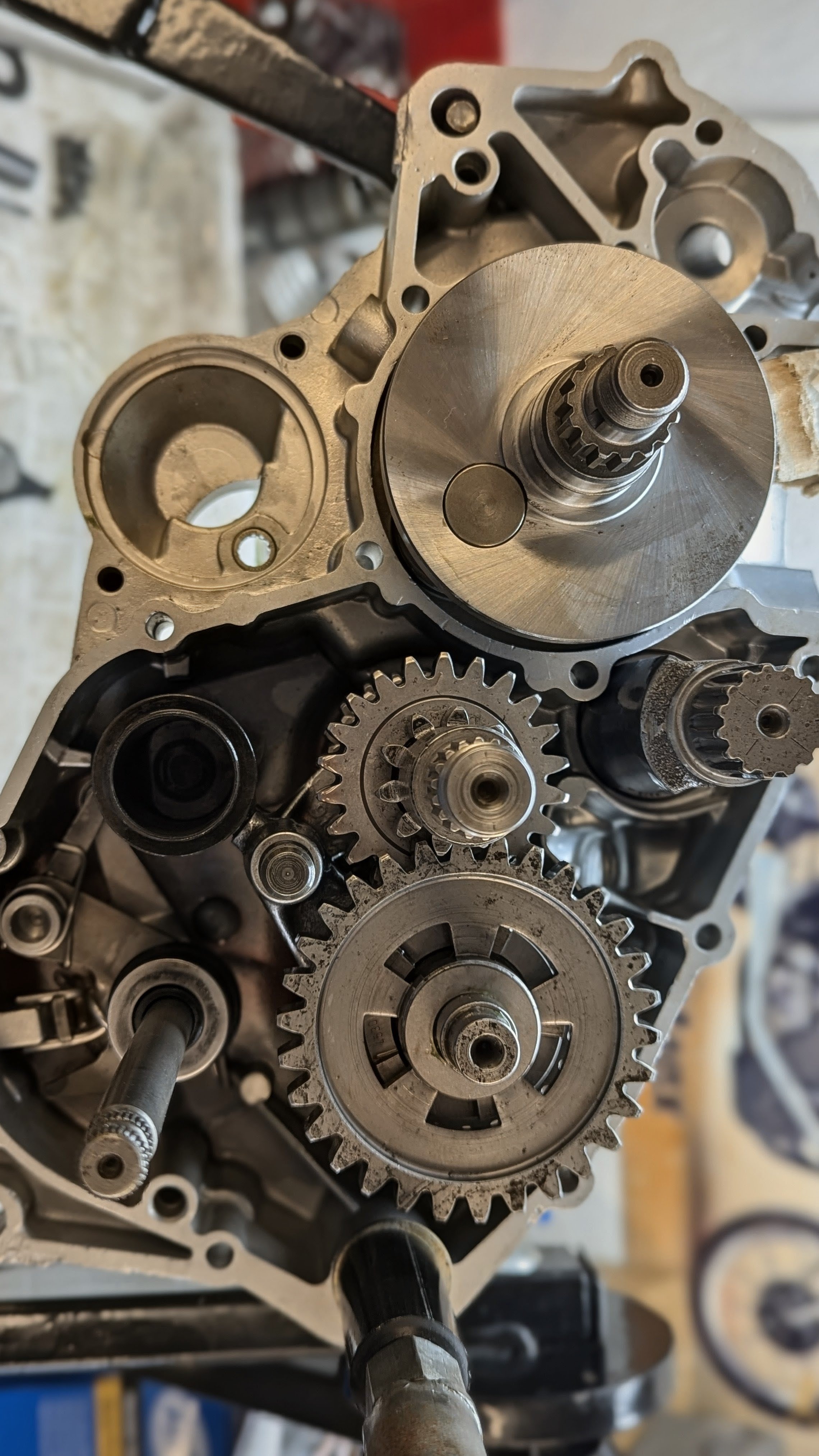 Close-up of an engine's internal gear system with metal gears and shafts inside a metallic casing.