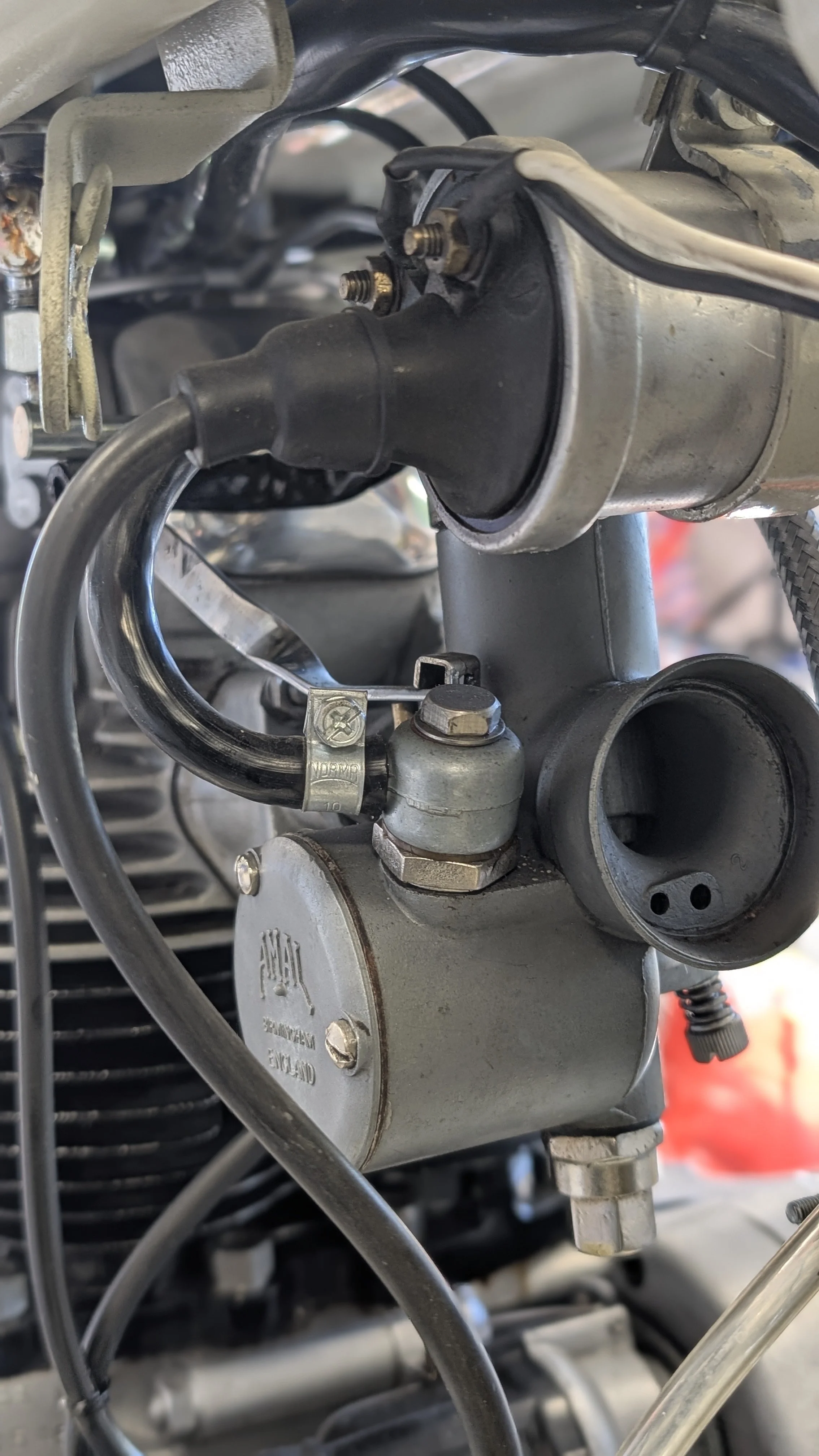 Close-up view of a mechanical component, likely part of a motorcycle engine, featuring metal parts, bolts, and electrical wiring.