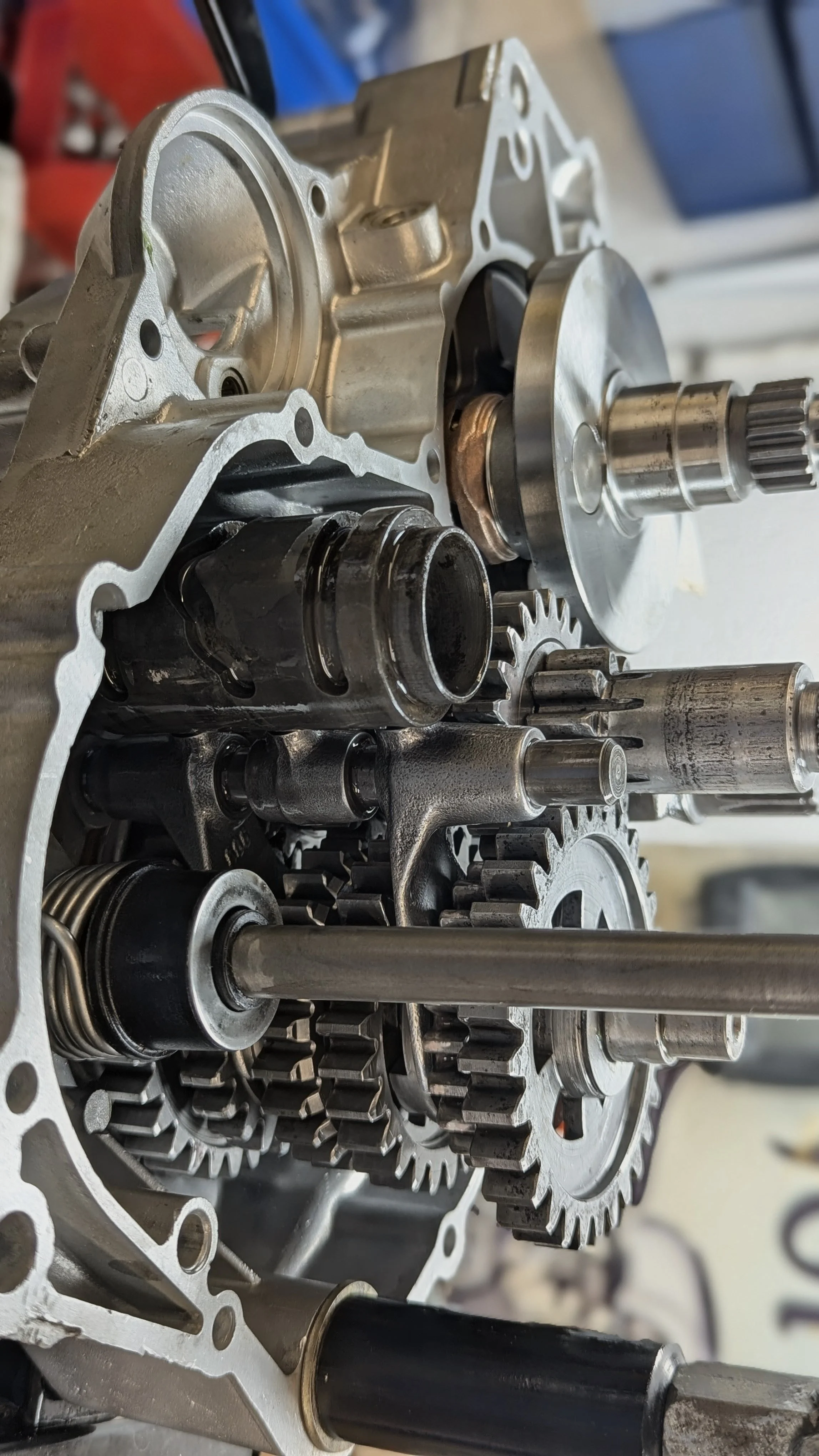 Close-up of an open engine transmission casing with gears and shafts inside.
