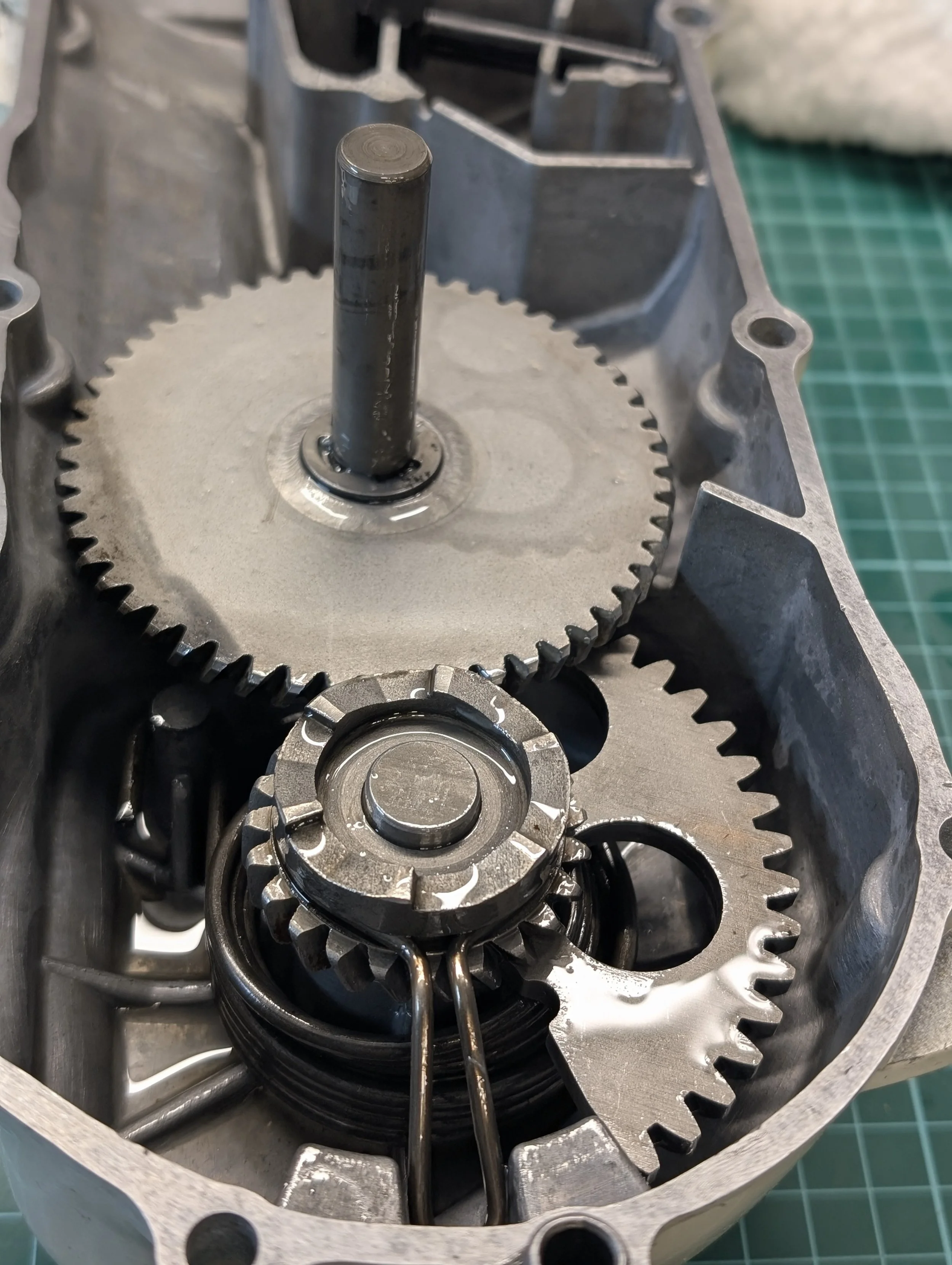 Close-up view of internal components of a mechanical device with gears and metal parts, possibly part of an engine or machinery.