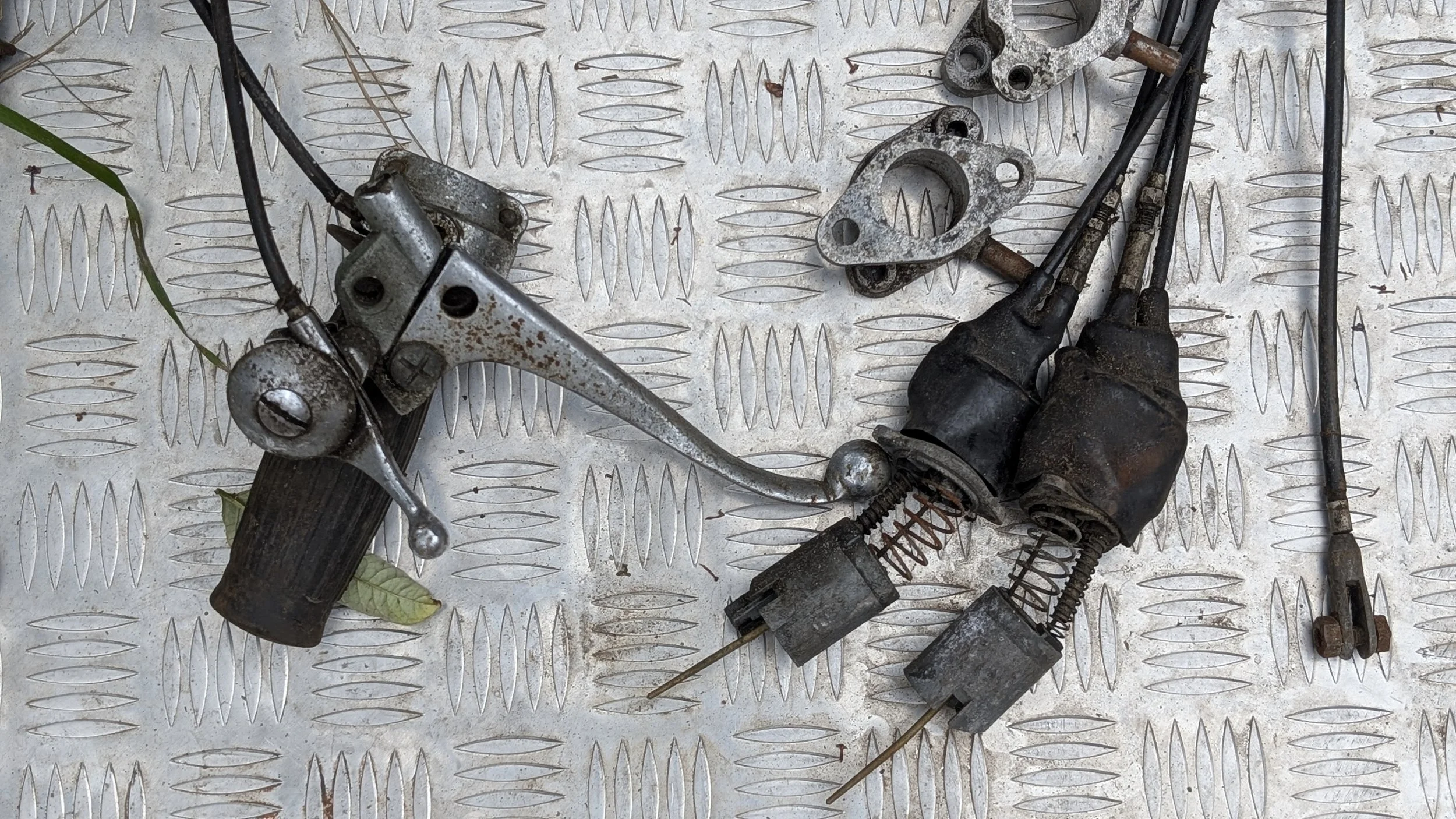 Triumph T100 Amal carburettor slides and handlebar controls. Cables for throttle choke and carburettor manifolds. Barn find Triumph T100 restoration project. 