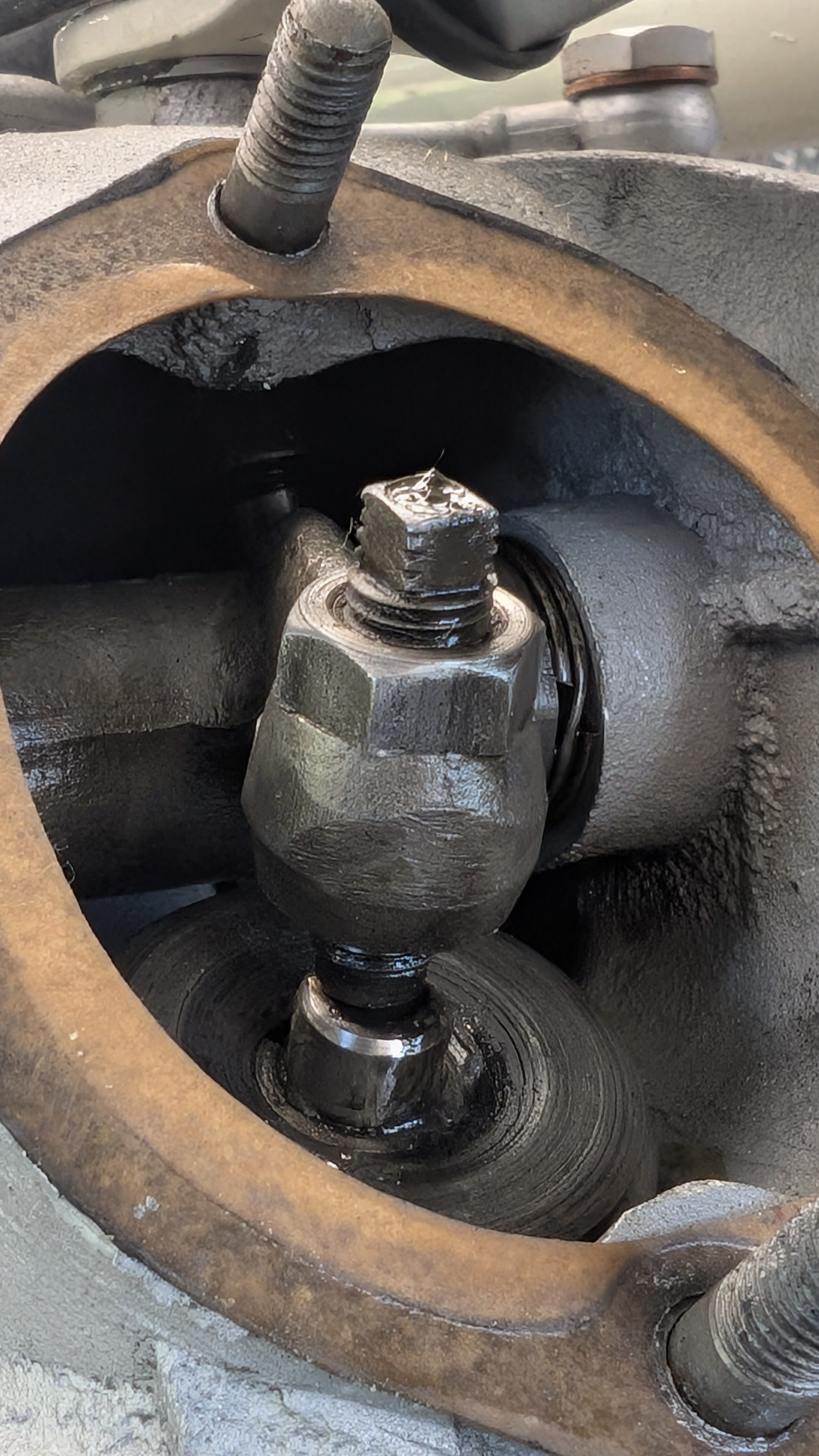 Close-up of a mechanical component showing a bolt, a nut, and a shaft inside a circular housing.