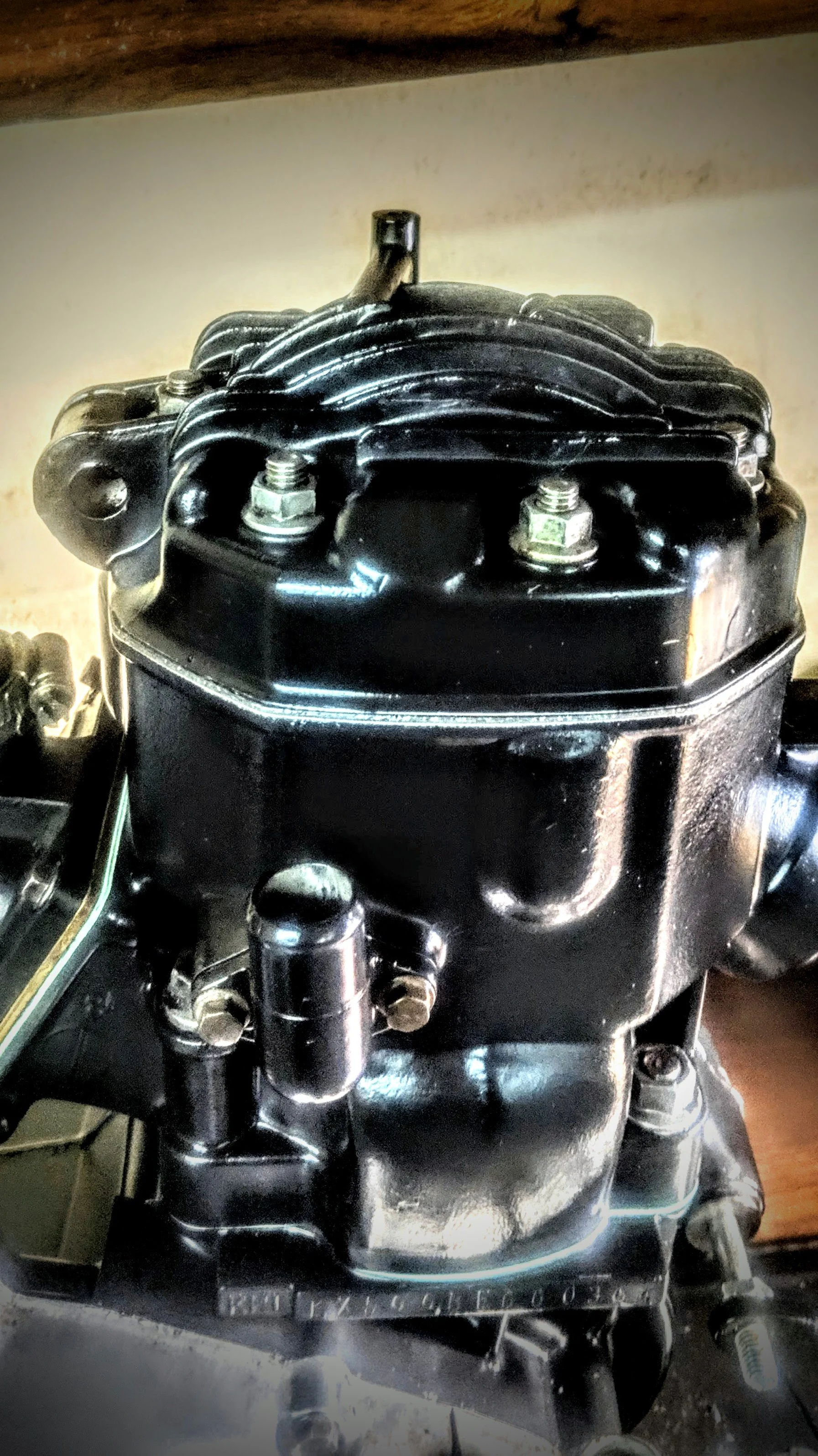Close-up of a black vintage motorcycle engine with shiny metal parts.