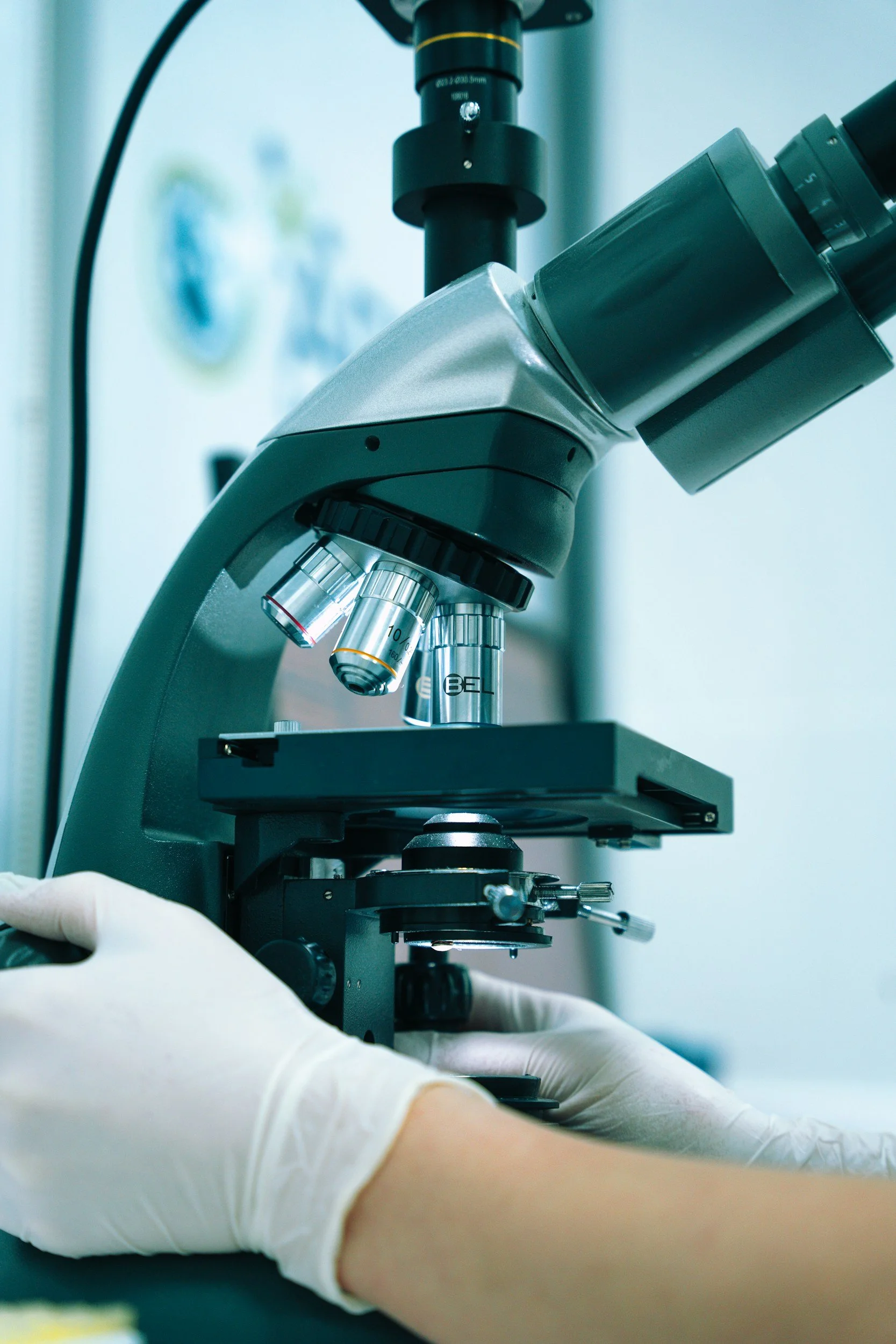 A scientist using a microscope in a laboratory setting.