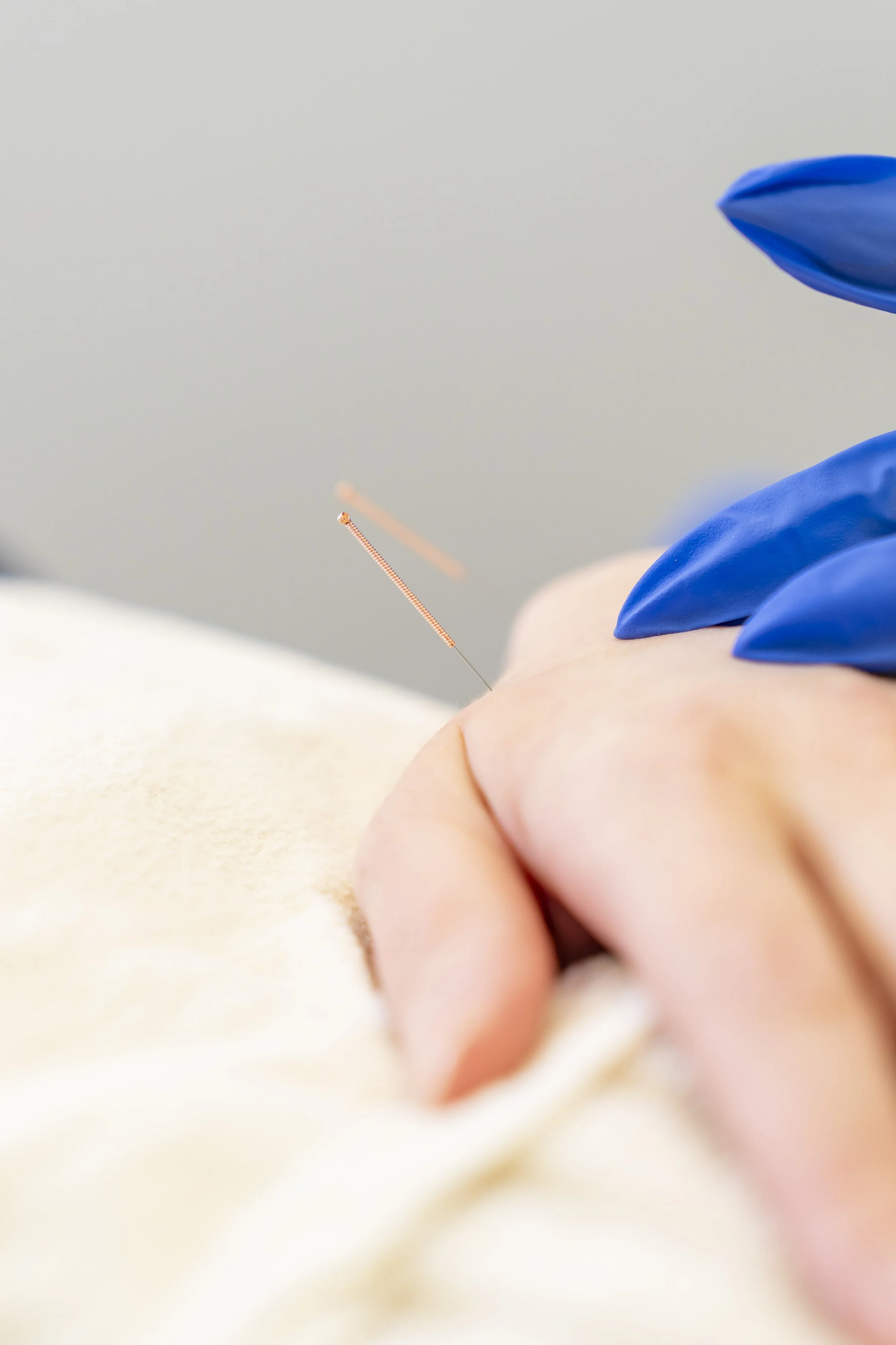 Close-up of a medical or laboratory procedure involving a needle and gloved hands.