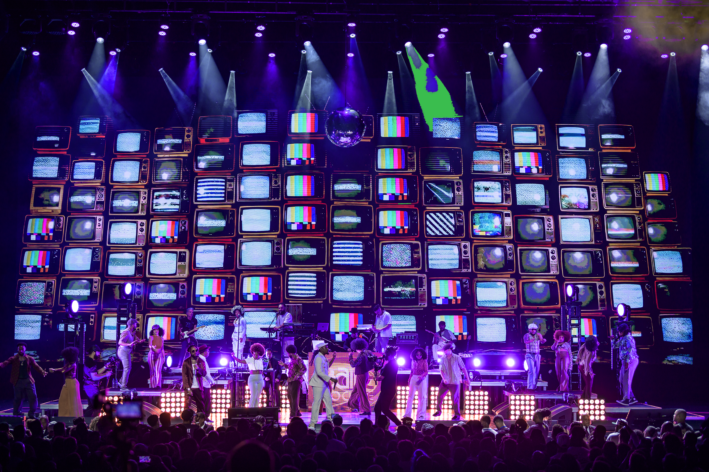 Palco de show com músicos, painéis de vídeo e iluminação cênica