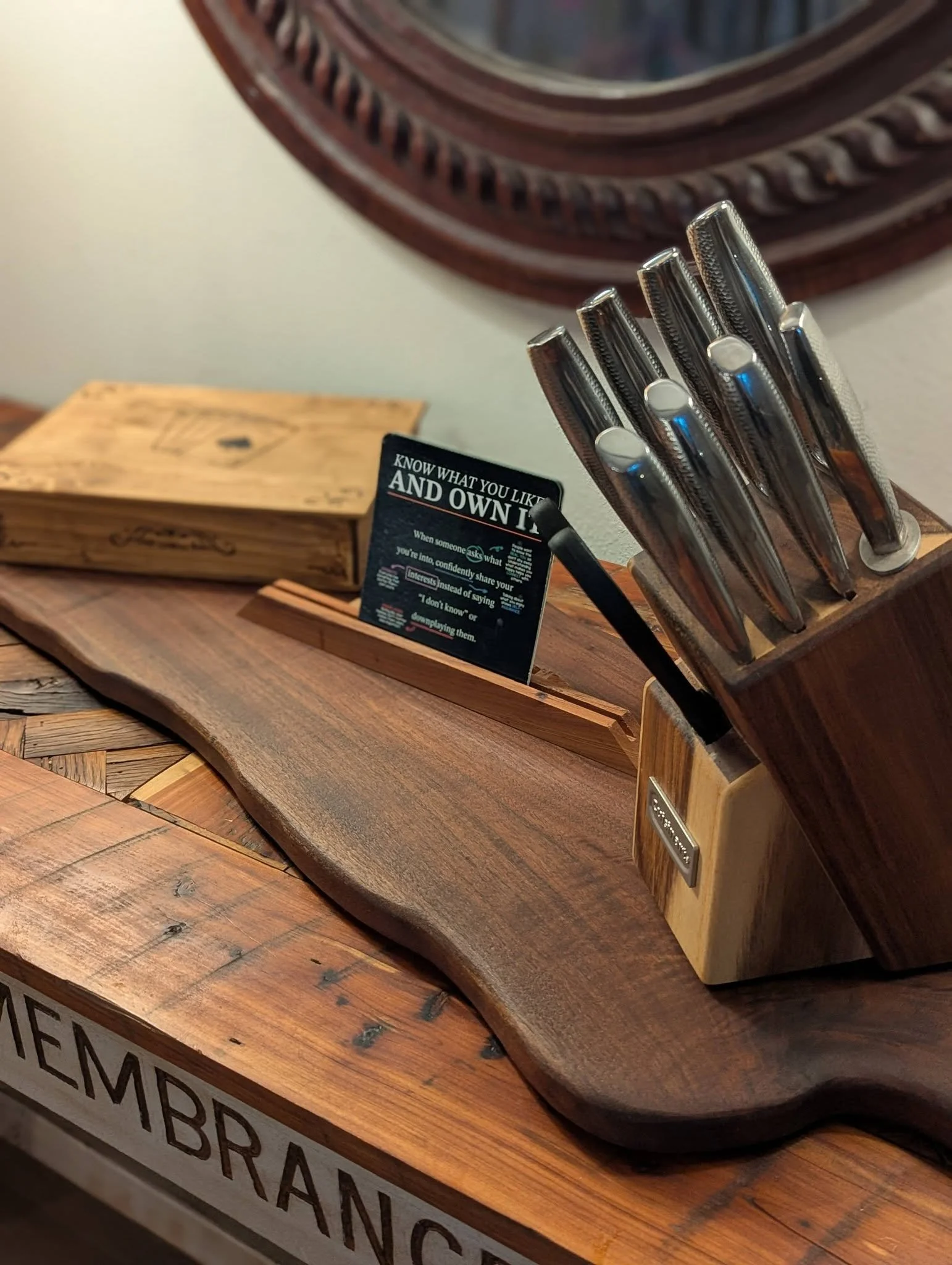 Wooden table with a display of grooming and shaving razors, a promotional sign, and a vintage wooden box.