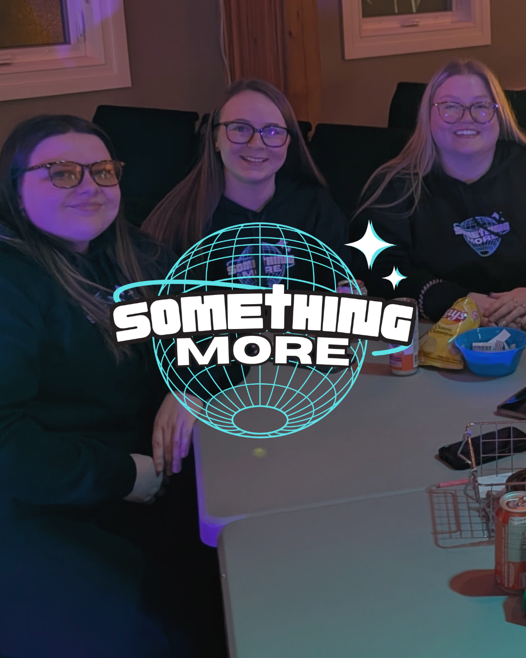 Three young women sitting at a table with snacks and drinks, smiling at the camera. Overlaid is a graphic of a globe with the text 'SOMETHING MORE' and star accents.