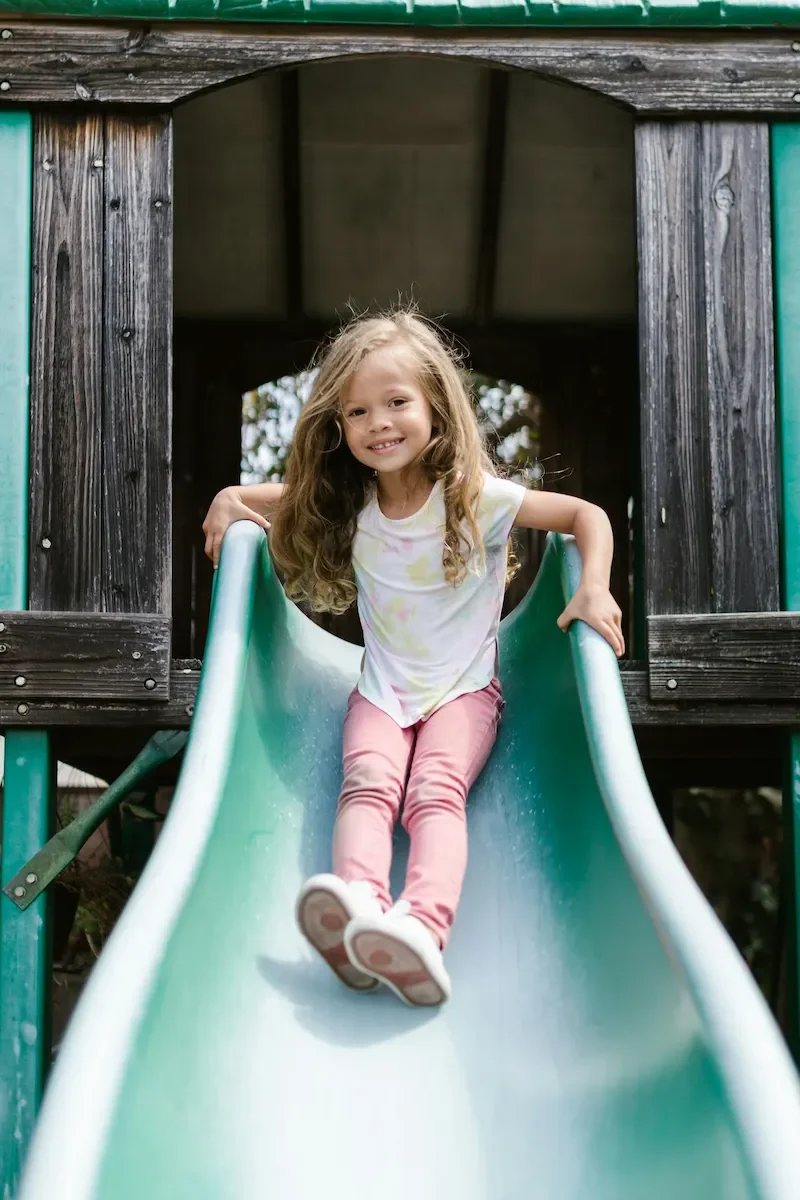 Child playing on a clean backyard playset slide