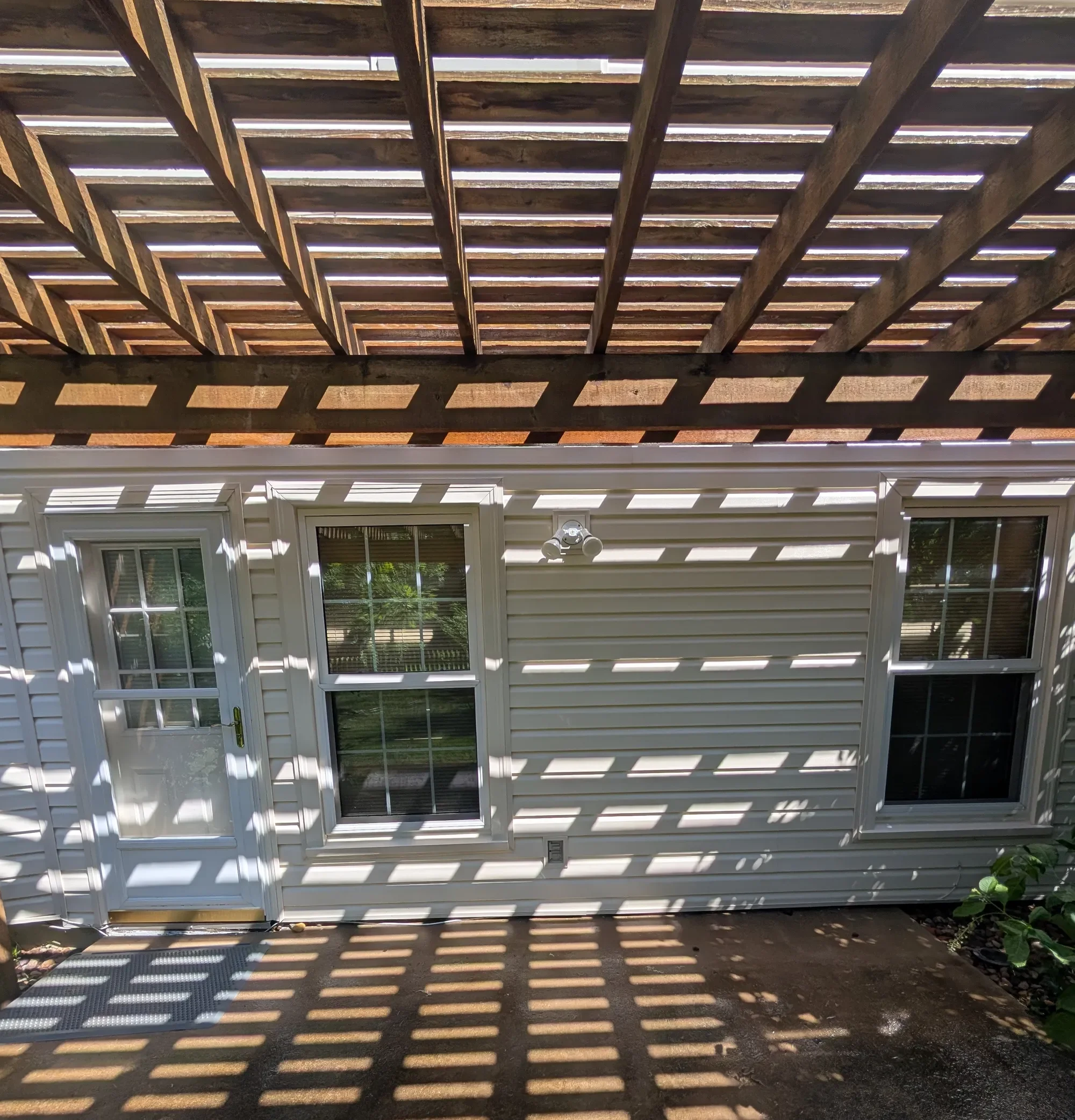 Clean house siding under pergola after soft washing by CurbSprout — Olathe, Johnson County KS