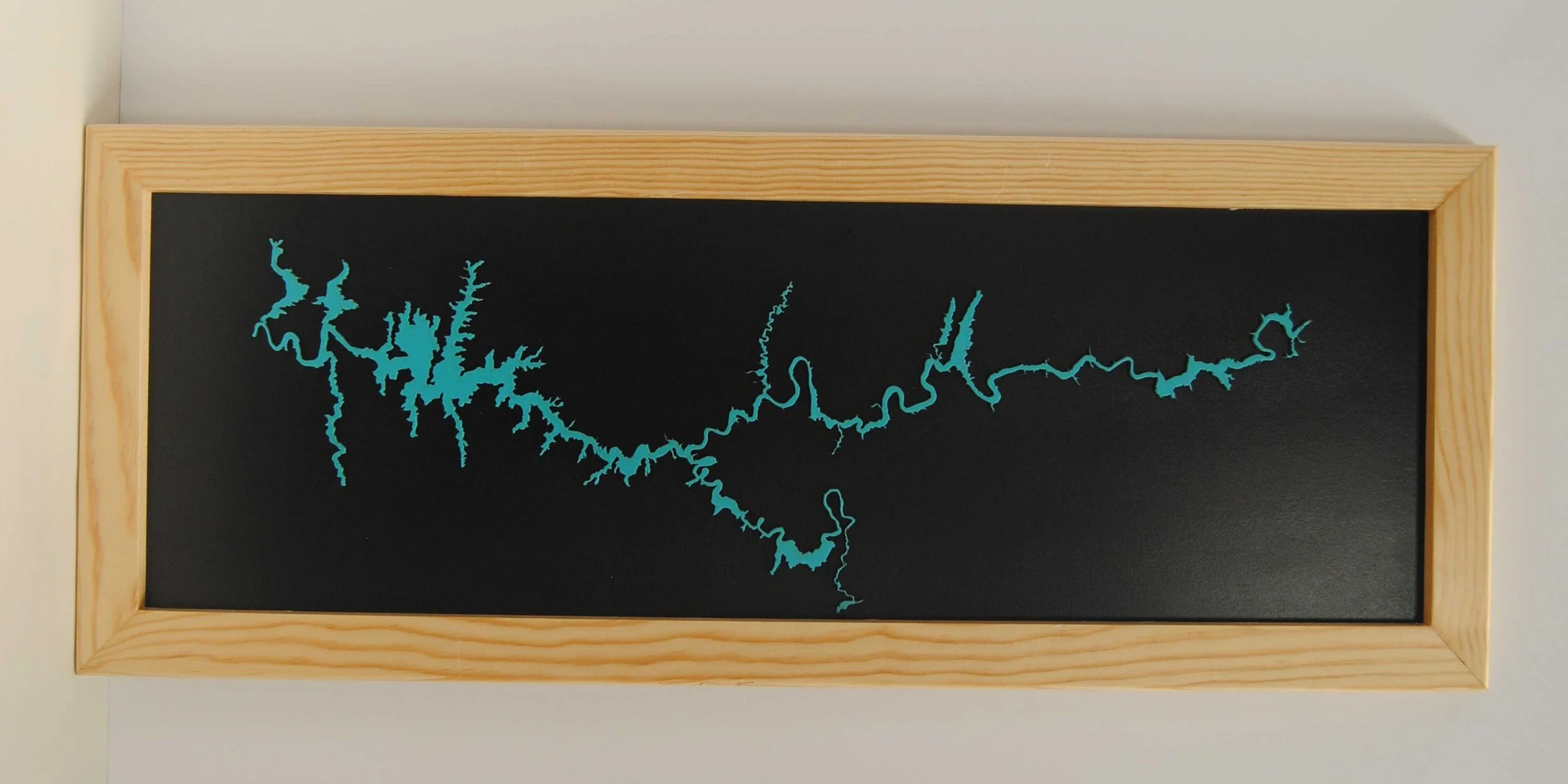 Laser cut profile of Lake Powell set of a black background. Cutout can be Turquoise, Gold, or natural wood. 12 x 32 inches. Larger ones available, so far up to 12 feet long