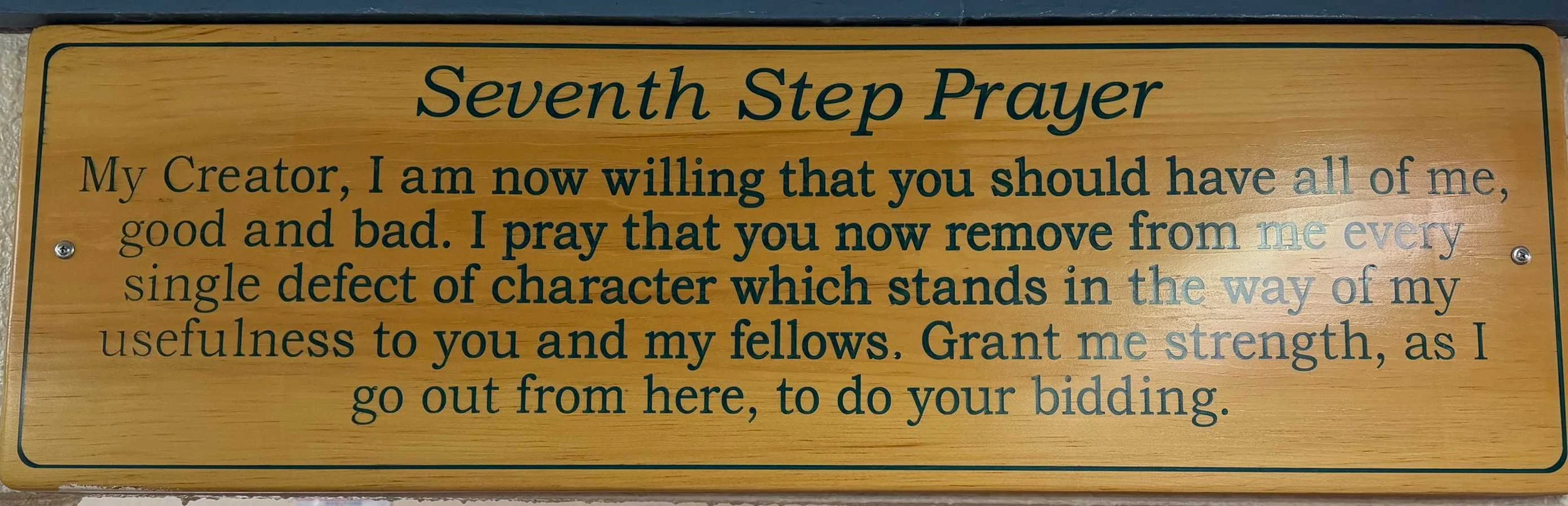 A wooden plaque with the title 'Seventh Step Prayer' and a prayer written on it, asking for strength, guidance, and removal of character defects.