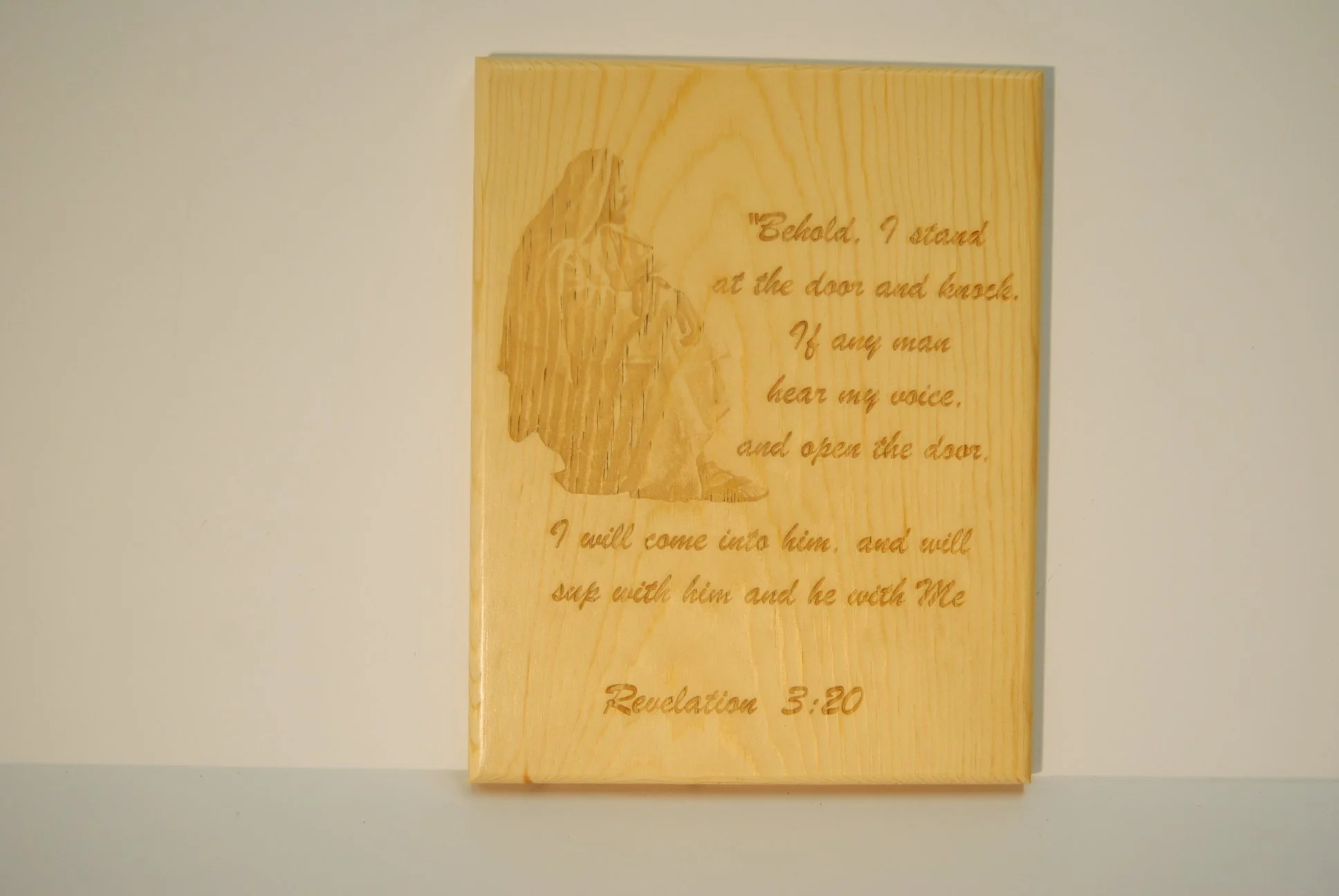 Wooden plaque with Jesus Christ illustration and a quote from Revelation 3:20 about standing at the door and knocking.
