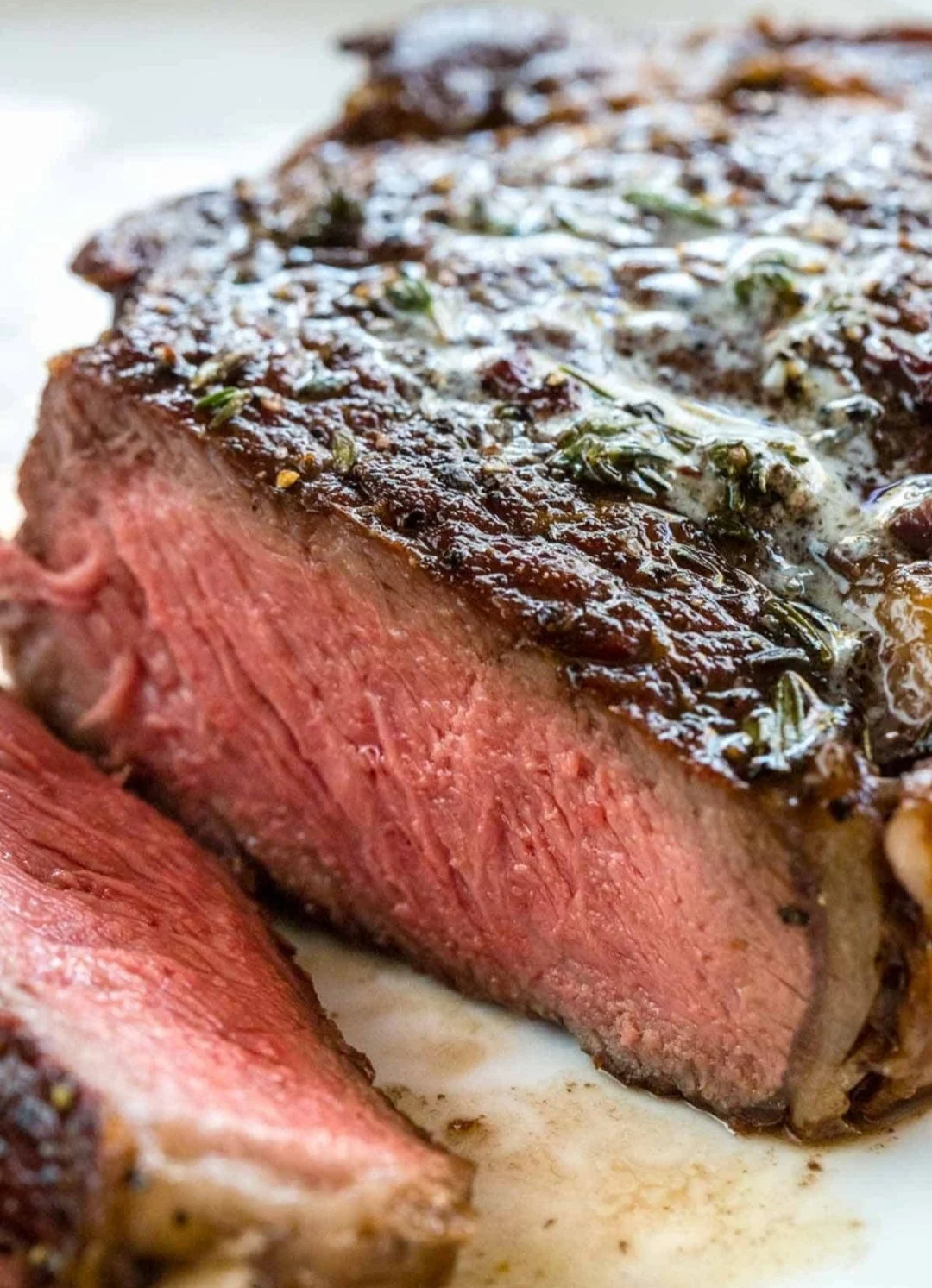 Close-up of a perfectly cooked medium-rare steak with a seasoned crust and pink center.