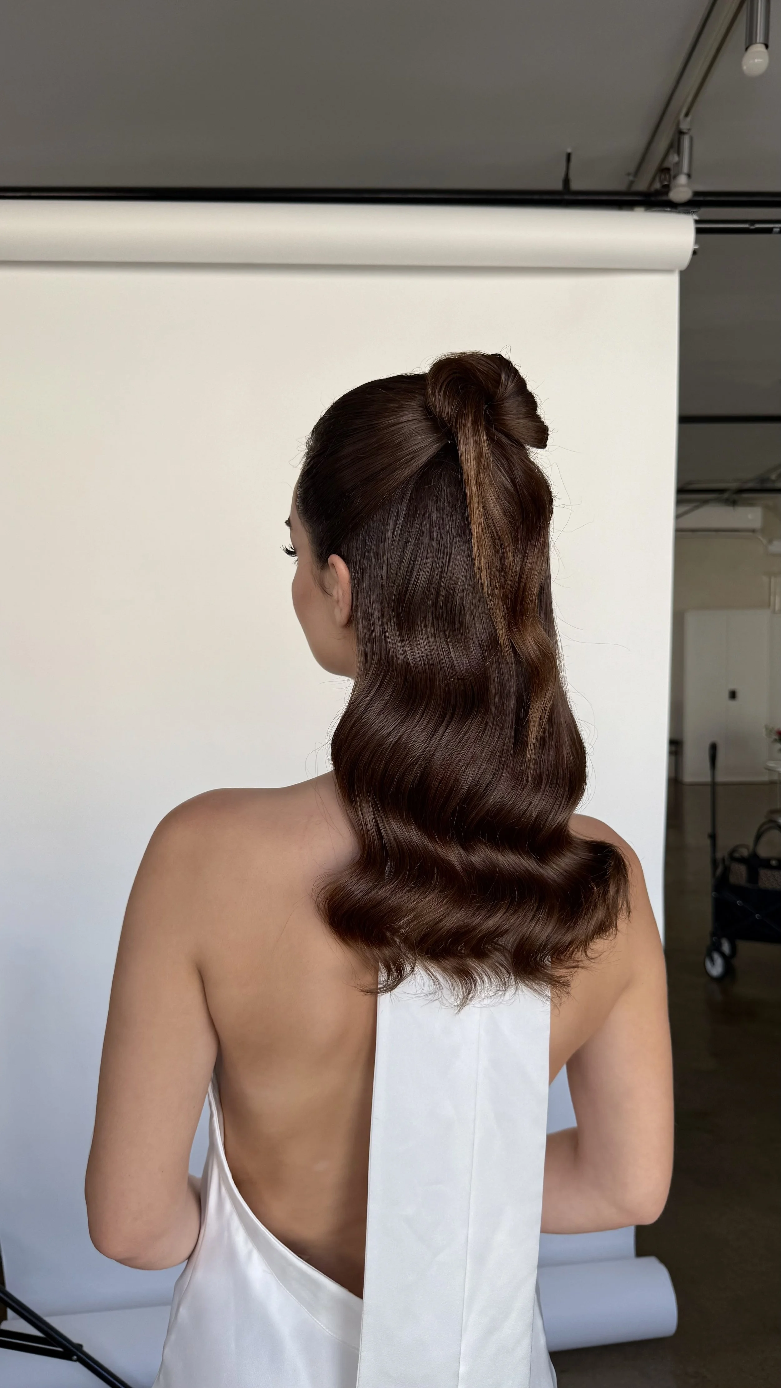 Bridal half-up hairstyle with sleek high ponytail — wedding hair by ESQAO Academy Los Angeles