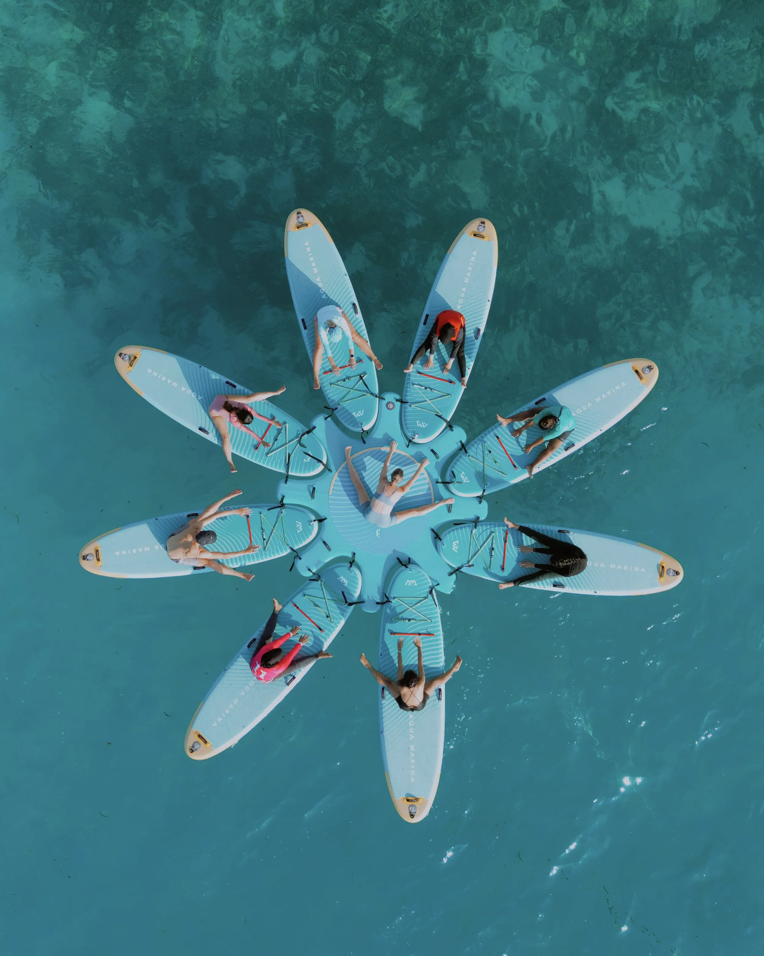 Aerial view of guests SUP Yoga in turquoise Maldives lagoon, Holistic Escapes retreat