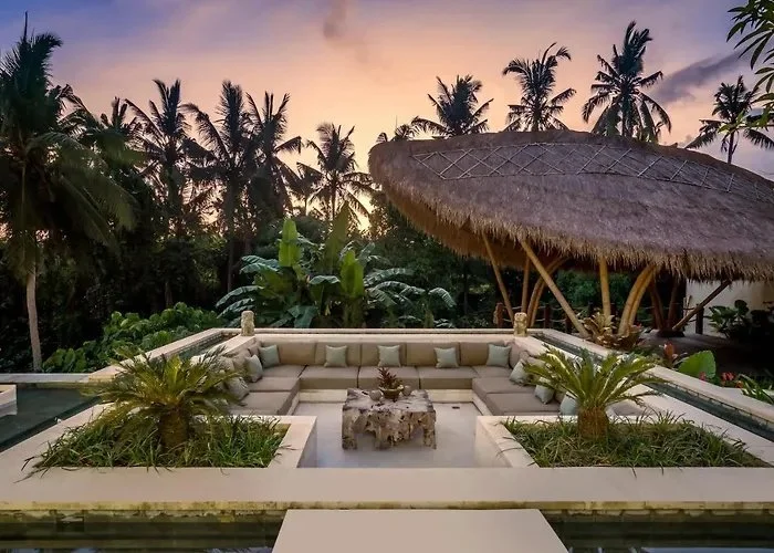 Tropical sunset garden with thatched pavilion and cushioned seating at Bali yoga and pilates retreat Indonesia evening relaxation space