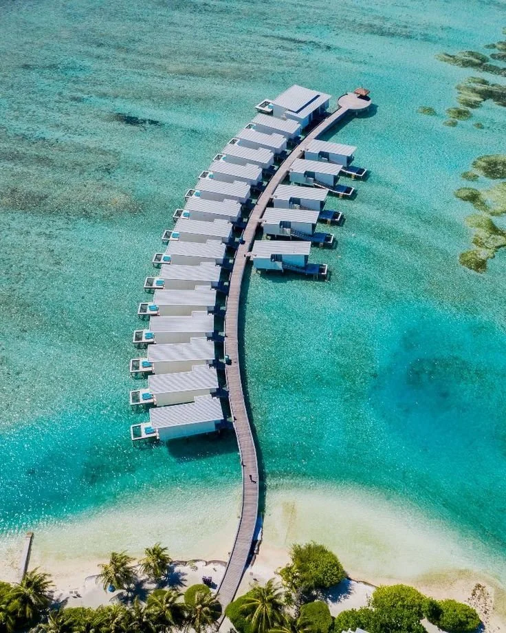 Overwater bungalows at luxury yoga and pilates retreat in Sumba Indonesia with turquoise ocean views and tropical beach