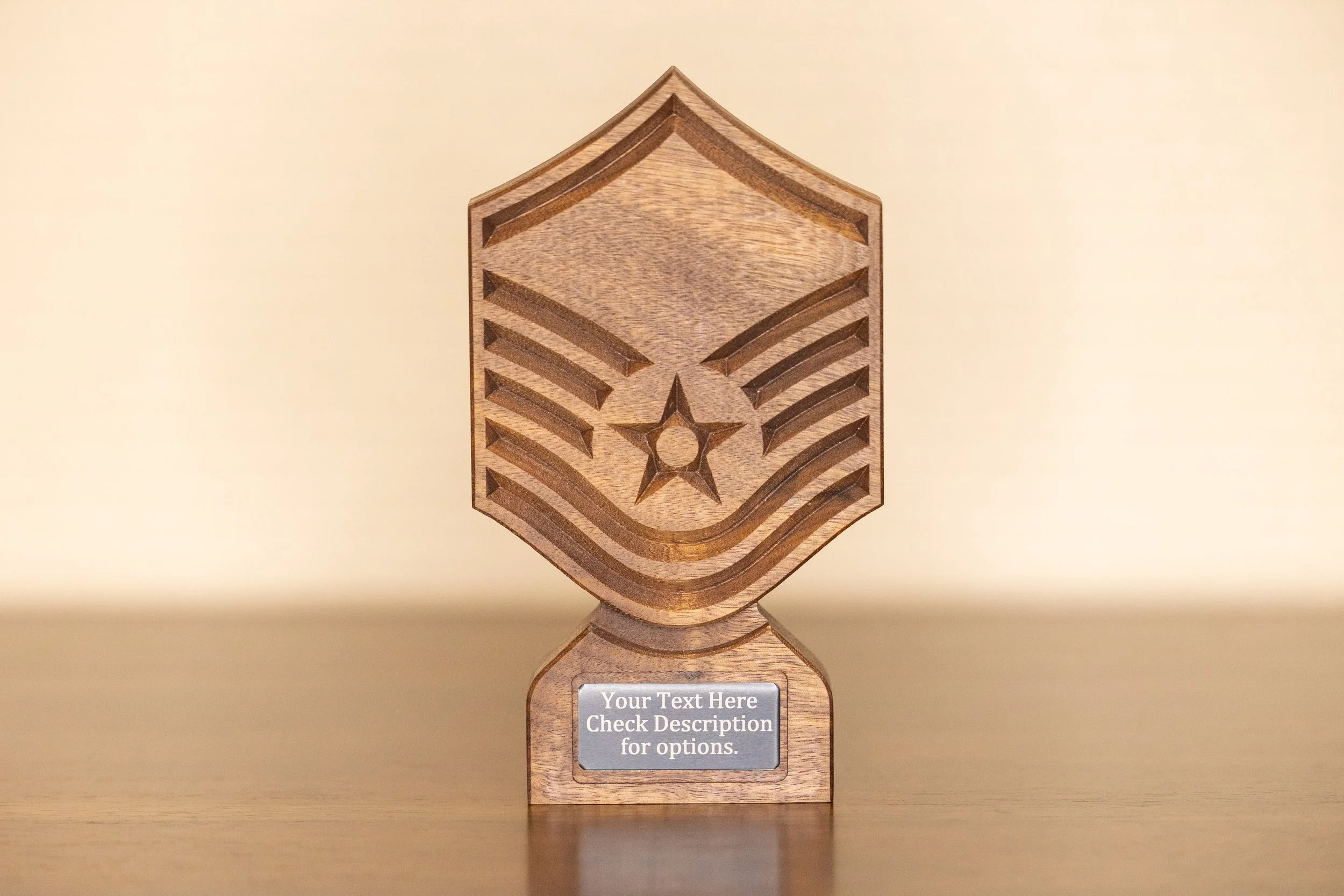 Wooden trophy with a star and chevron design, placed on a reflective surface against a plain background, with a customizable label for text.