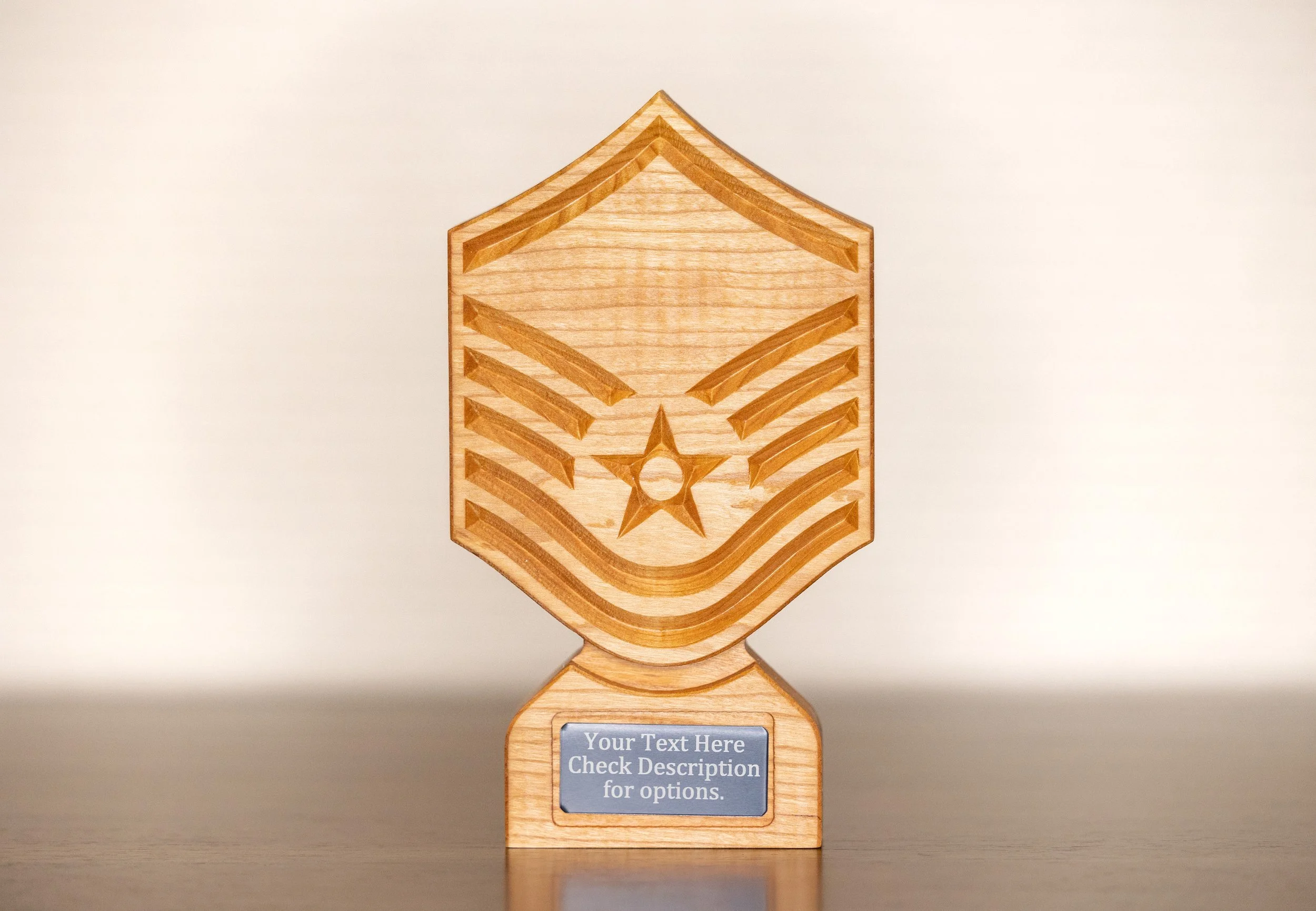 Wooden trophy with engraved star and stripes design, placed on a table with a placeholder plaque for personalized text.