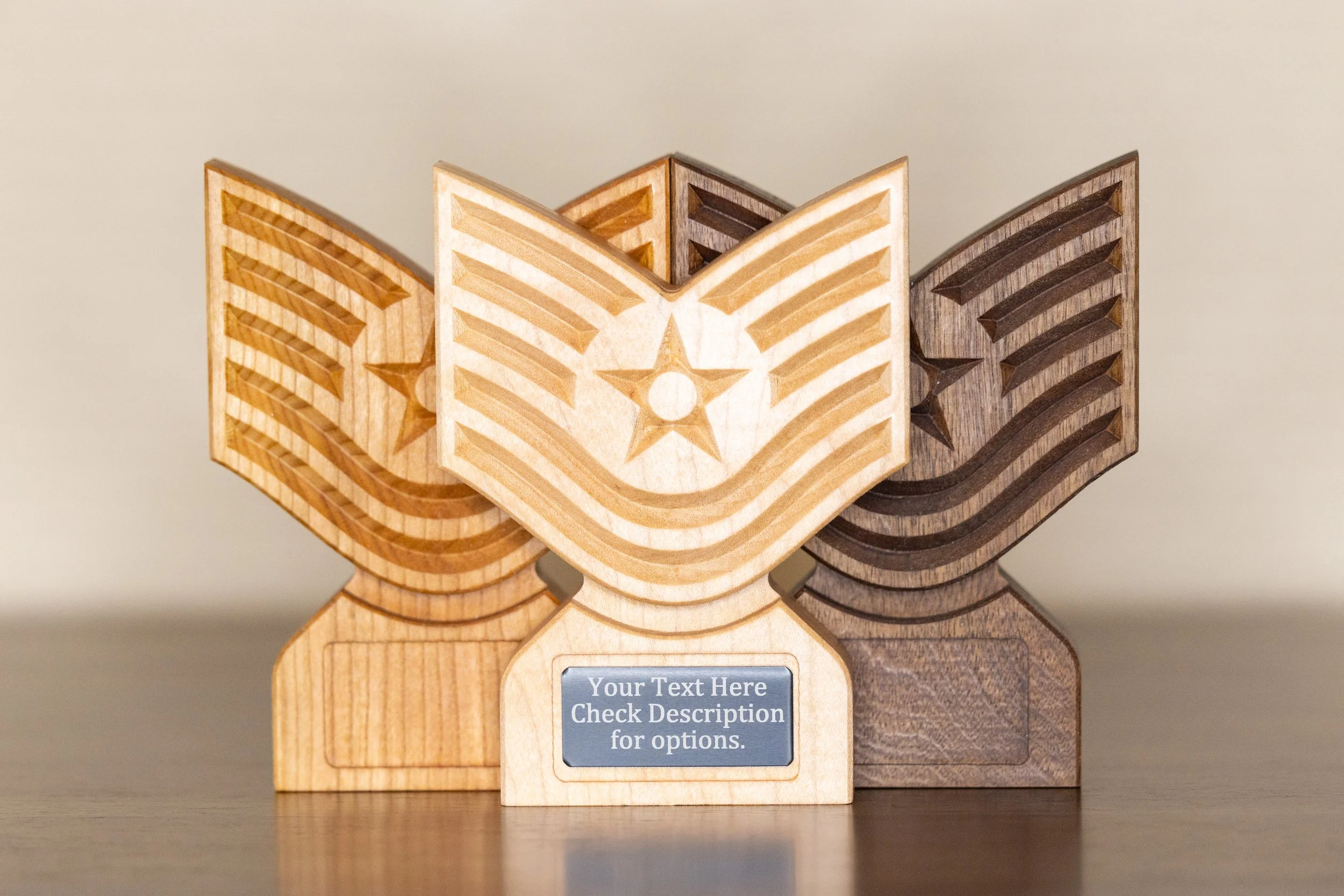 Three wooden house-shaped blocks with carved star and stripe patterns, arranged in a row on a flat surface.