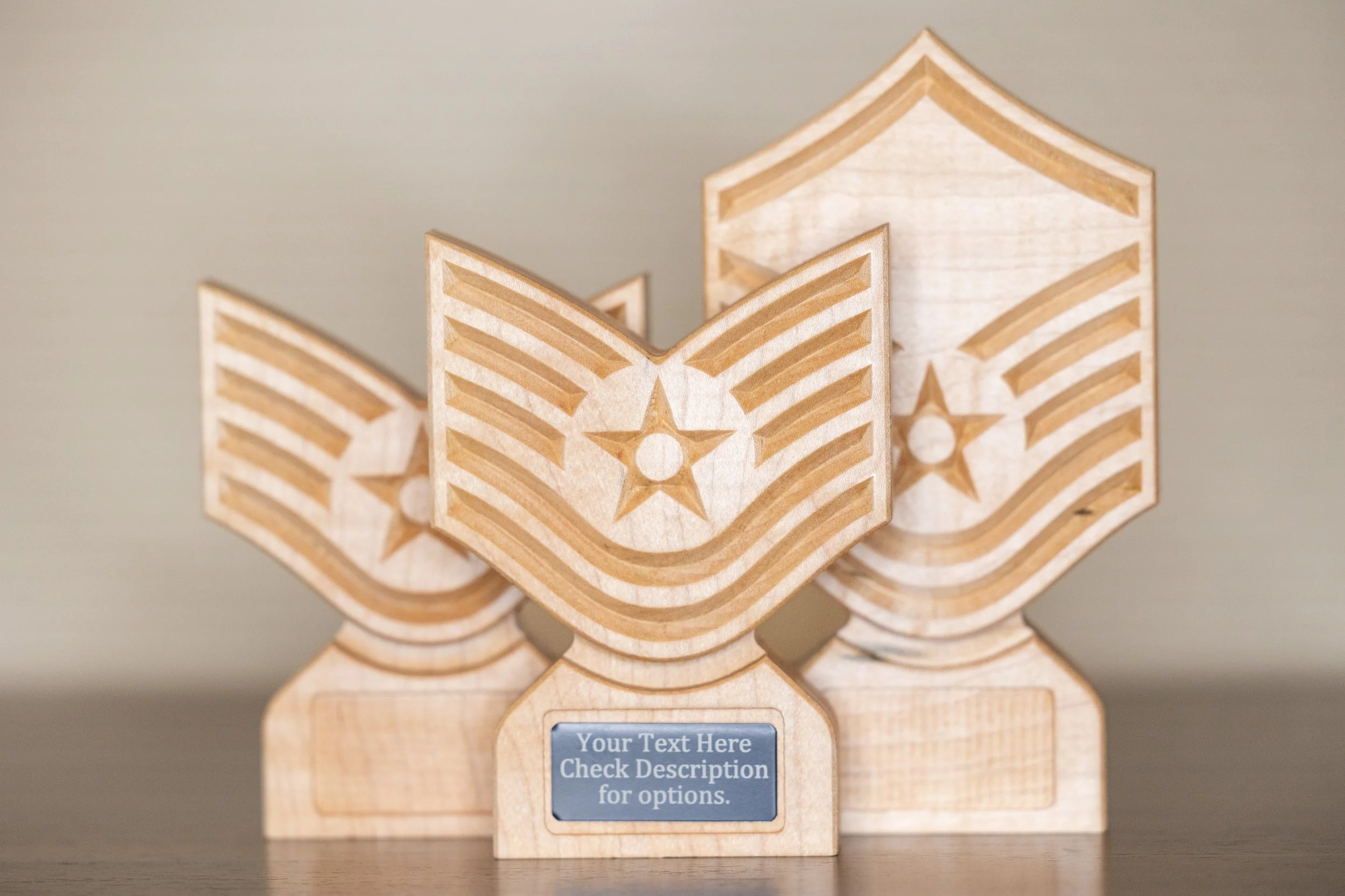 Wooden plaques with engraved stars and stripes, resembling American flags, displayed upright on a surface, with a placeholder text indicating customizable options.