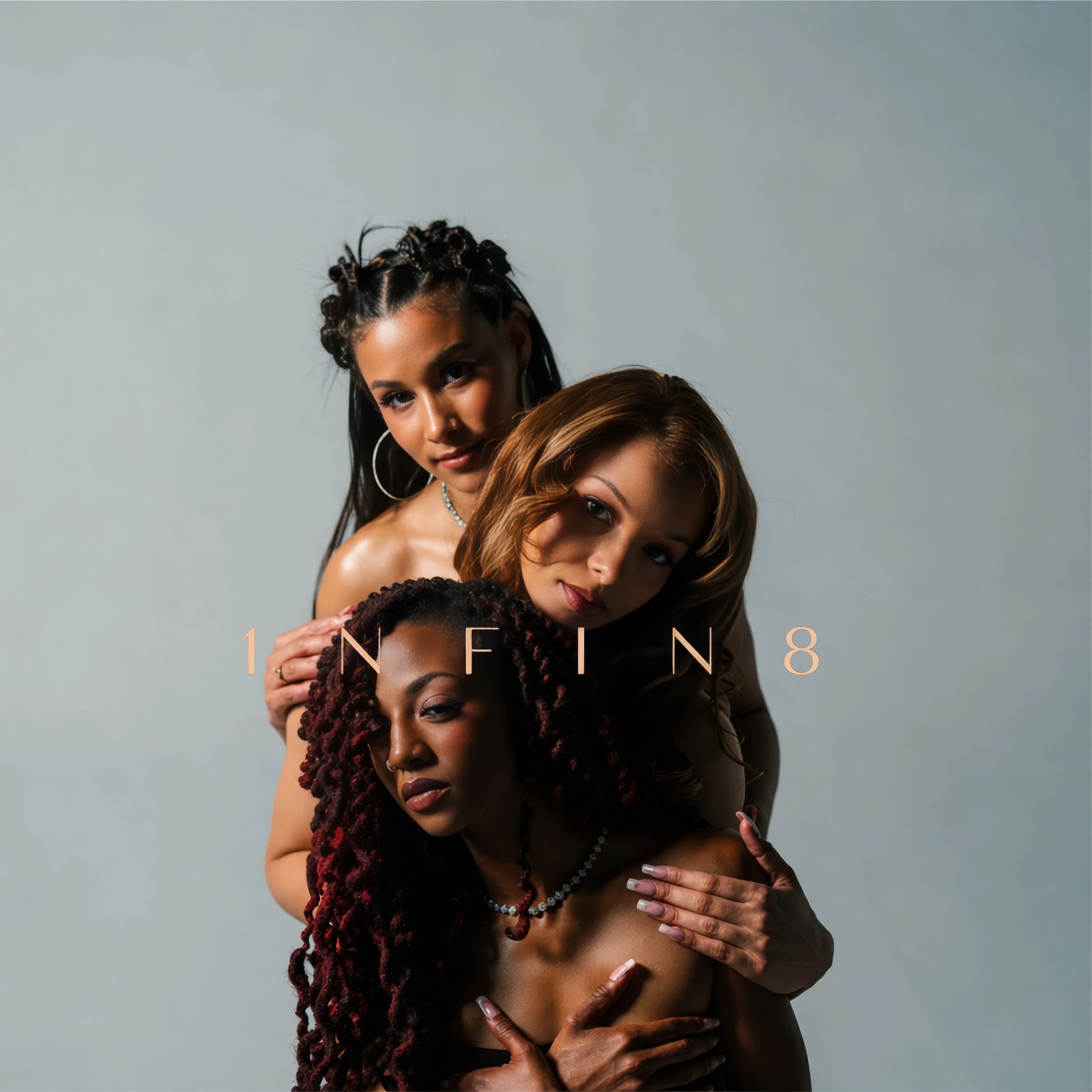 Portrait of four women with diverse features, partially visible, standing closely together against a plain background.