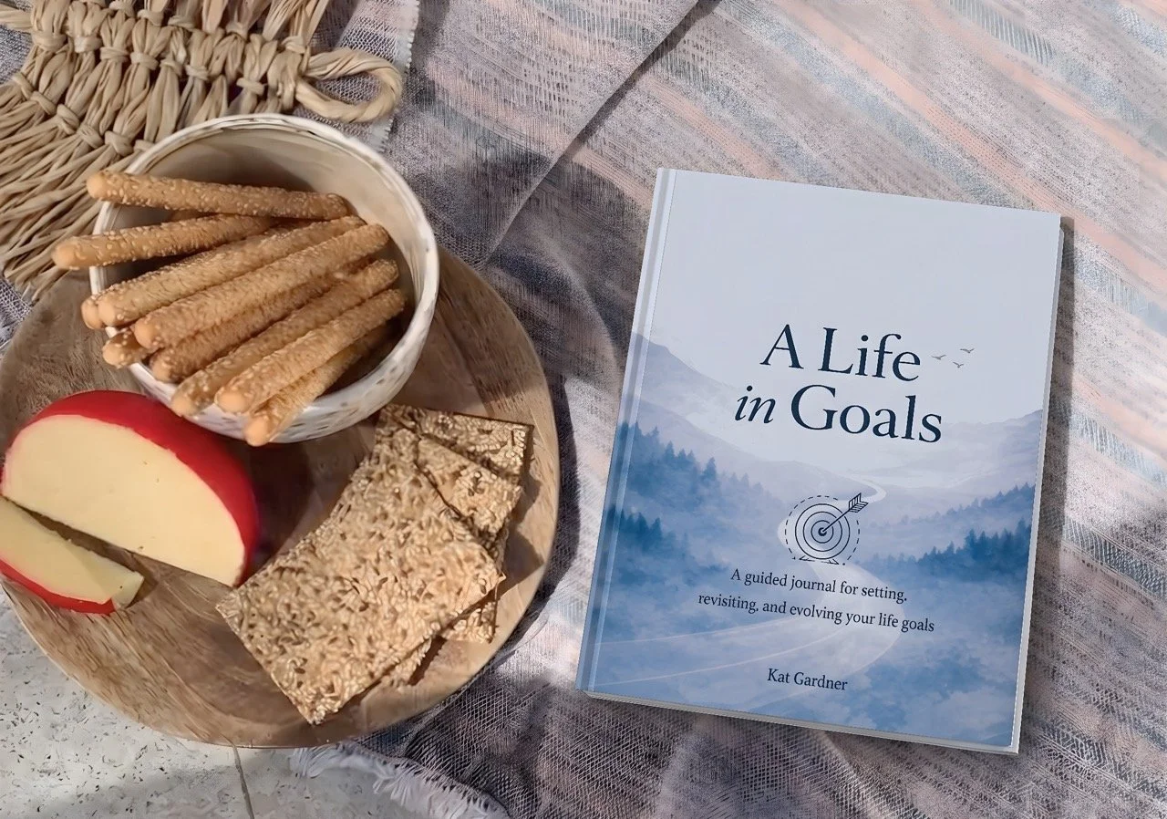 A Life in Goals guided journal beside a relaxed picnic, created for setting, revisiting and evolving your life goals.