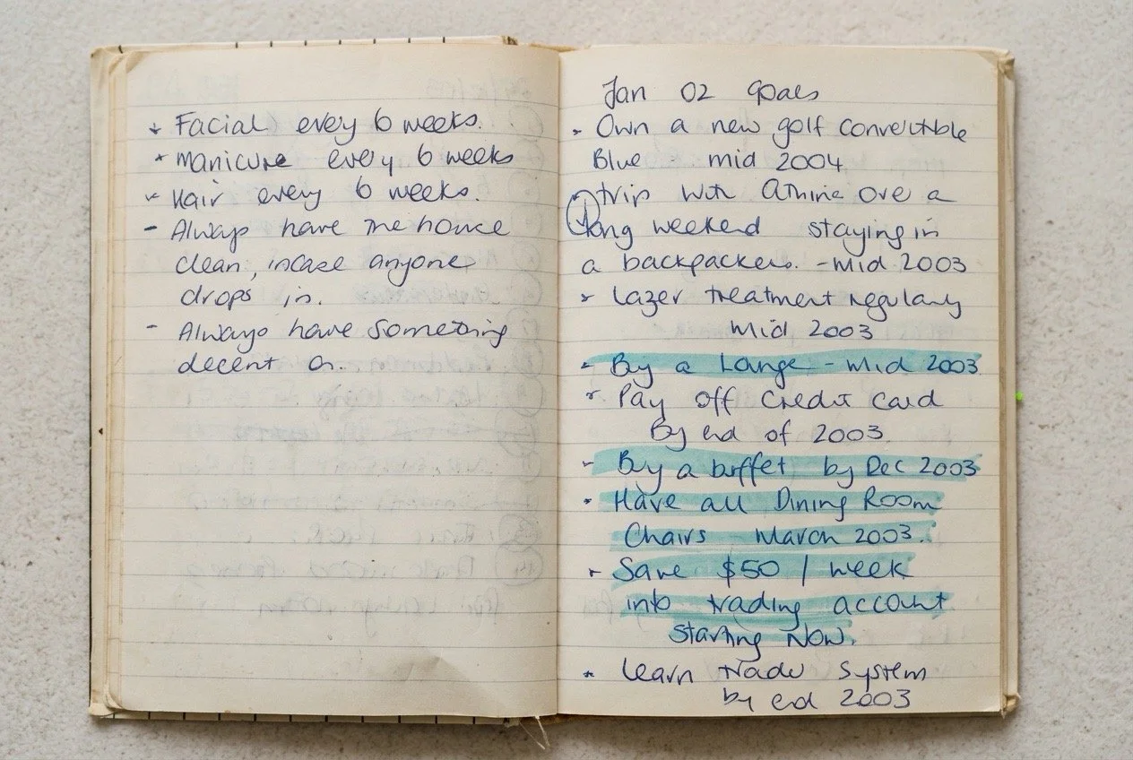 Original handwritten goals from 2002 covering saving, paying off debt, buying furniture, building a trading account, travel and everyday personal routines.