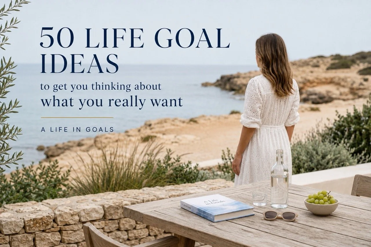Woman overlooking a coastal landscape beside an A Life in Goals journal, with text reading “50 Life Goal Ideas to get you thinking about what you really want.”