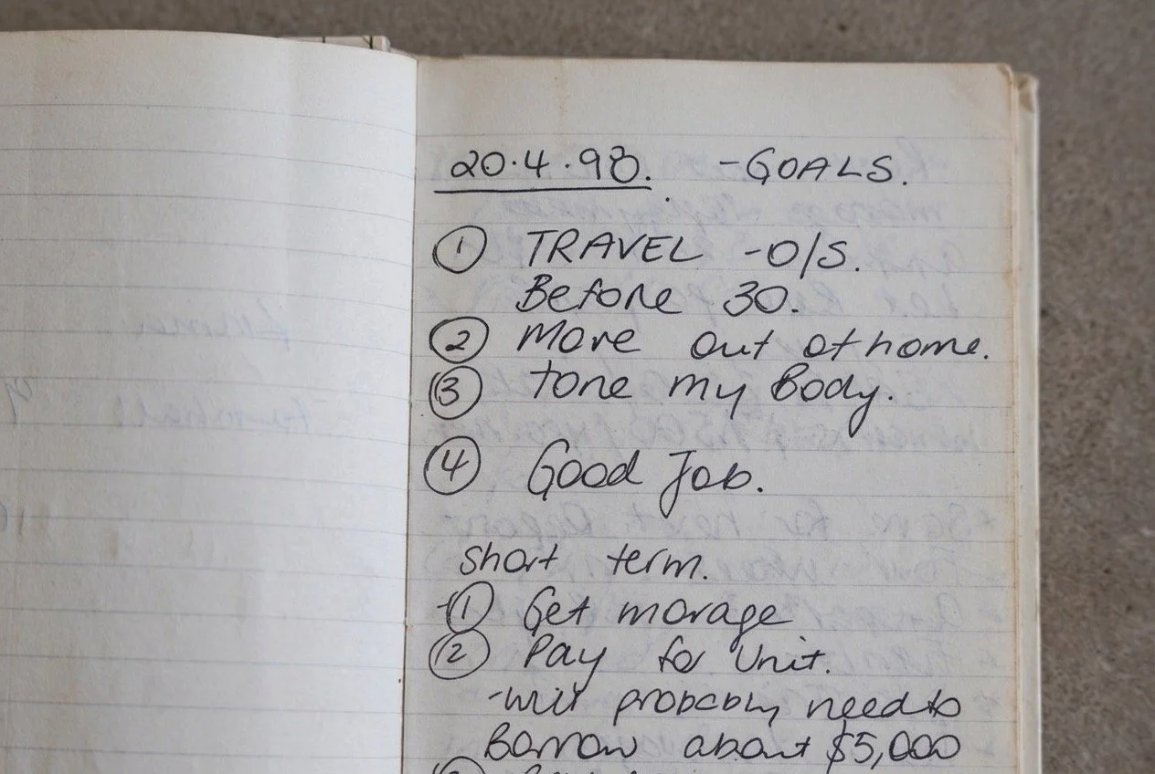 Close-up of an original handwritten goals list dated 20 April 1998, including travel before 30, moving out of home, getting a good job and short-term financial goals.