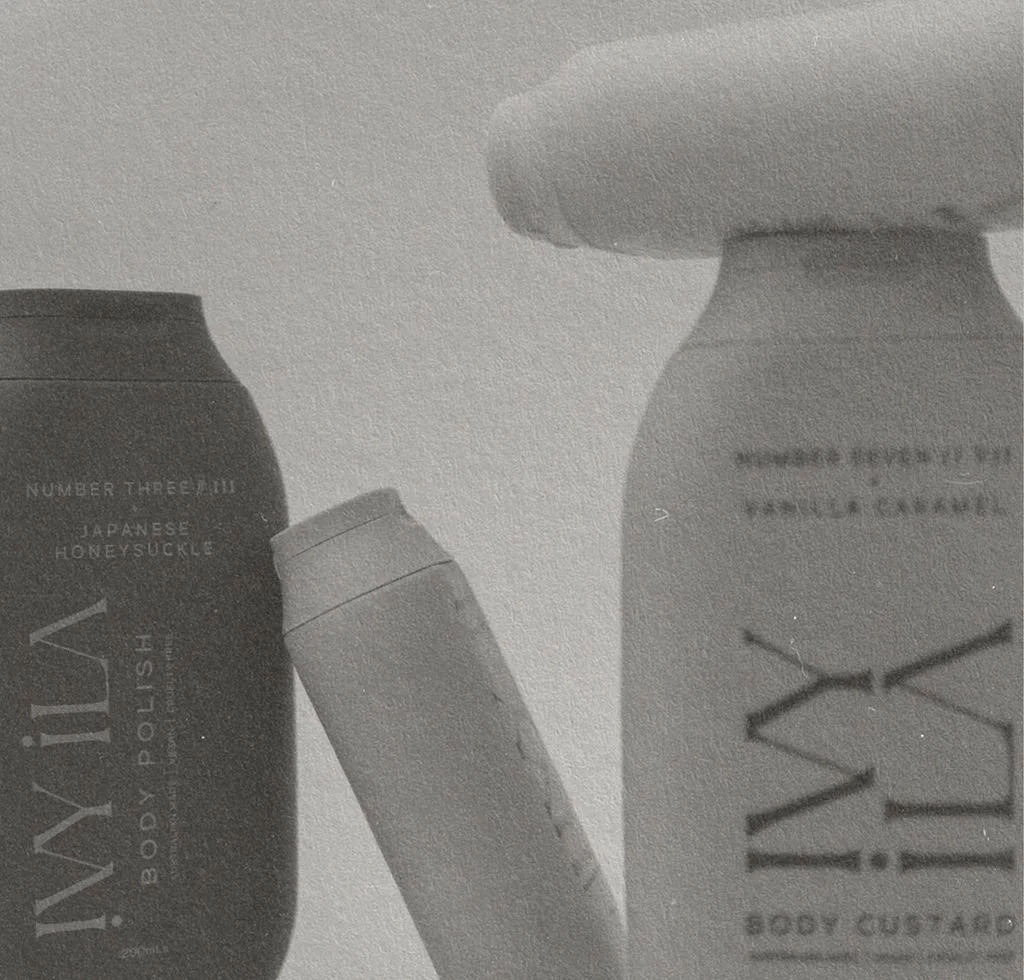 Two bottles of body care products and a small tube of cream or lotion on a flat surface.