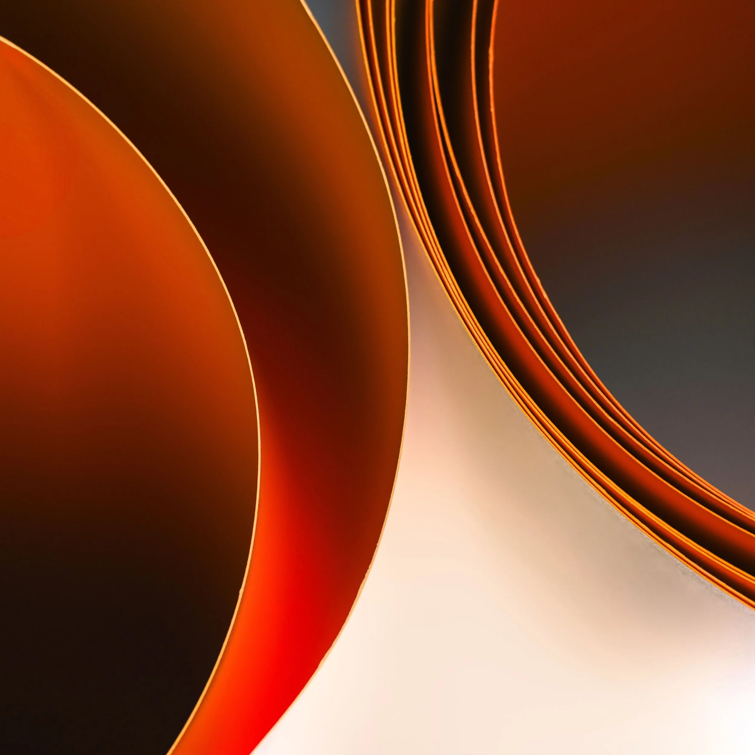 Dettaglio di una pagina di un libro o di un quaderno con le pagine leggermente arricciate di colore arancione e marrone, illuminata da una luce calda.