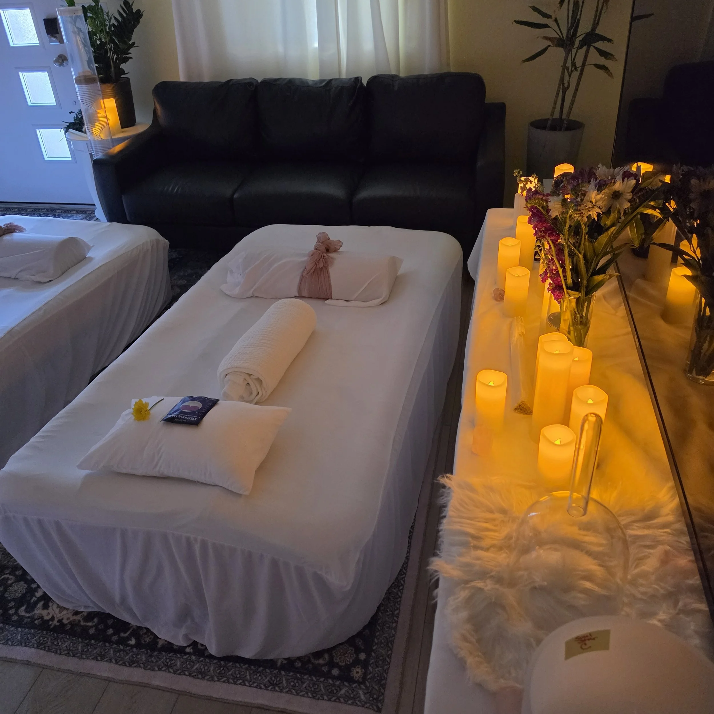 Elevated immersive sound bath space prepared with crystal singing bowls, candlelight, and cushioned beds designed to support relaxation, nervous system restoration, and intentional rest.