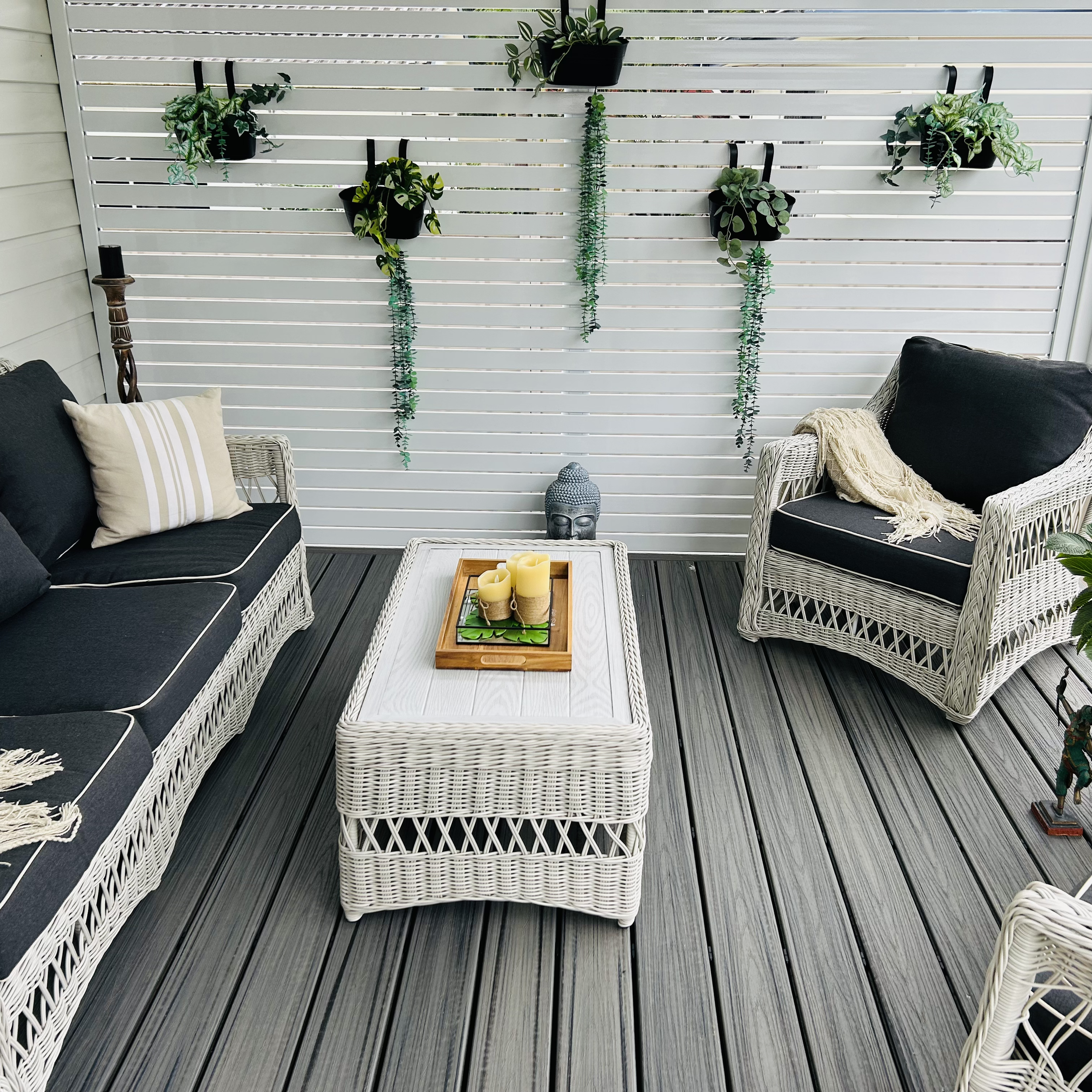 Covered grey composite deck with pergola and white privacy screen by Platinum Decks & Patios creating a coastal boho style