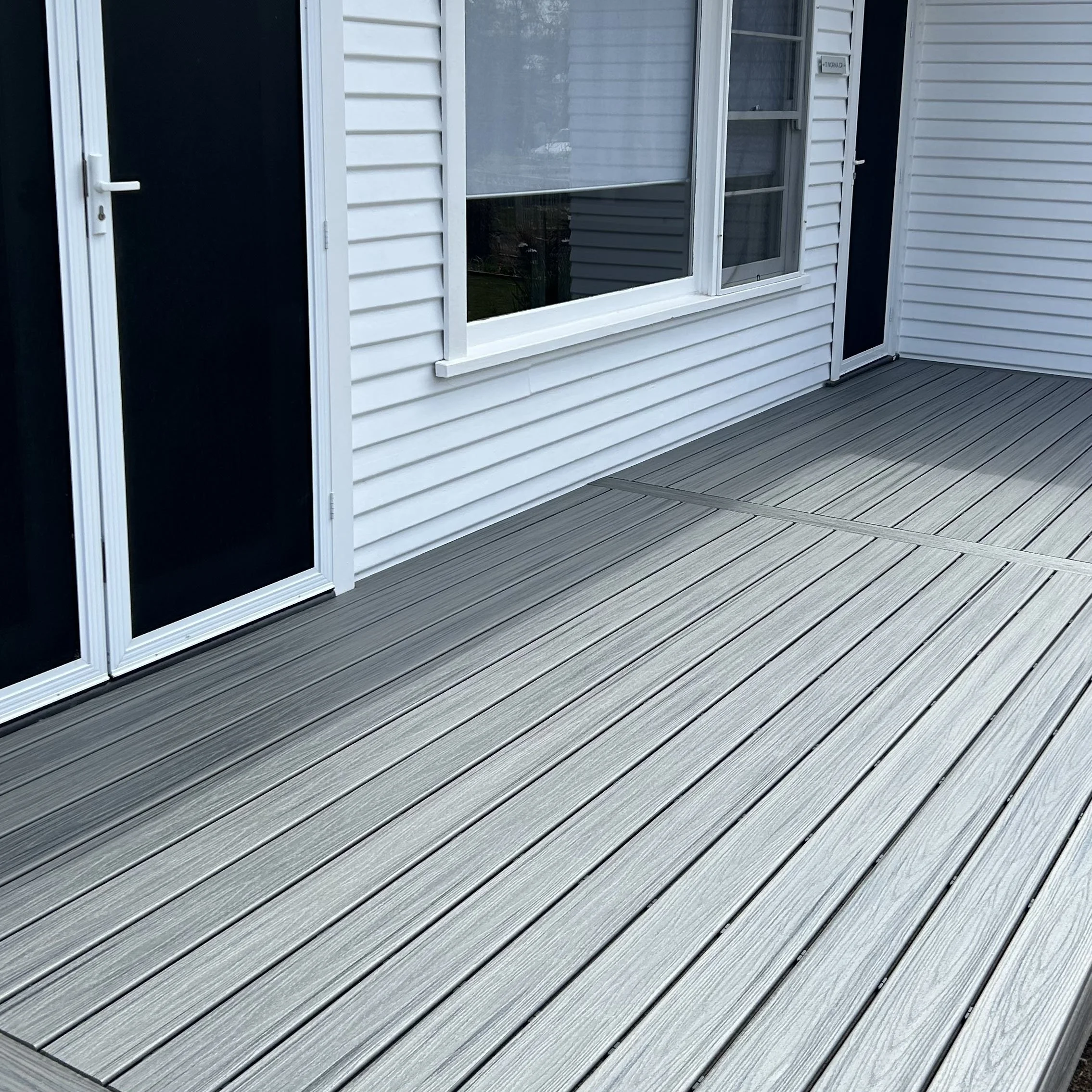 Close-up image of a Central Coast coastal home with modern composite deck and cusom privacy screen built by Platinum Decks. 