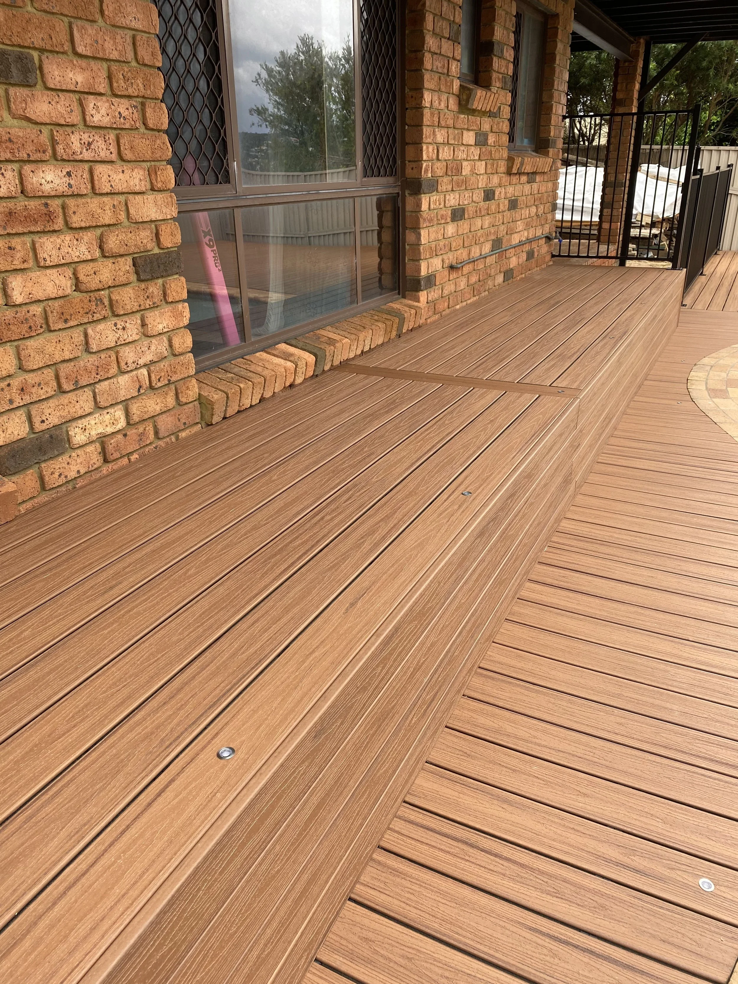 Backyard pool Trex Tikitorch decking designed by Platinum Decks to blend tropical landscaping with refined outdoor architecture