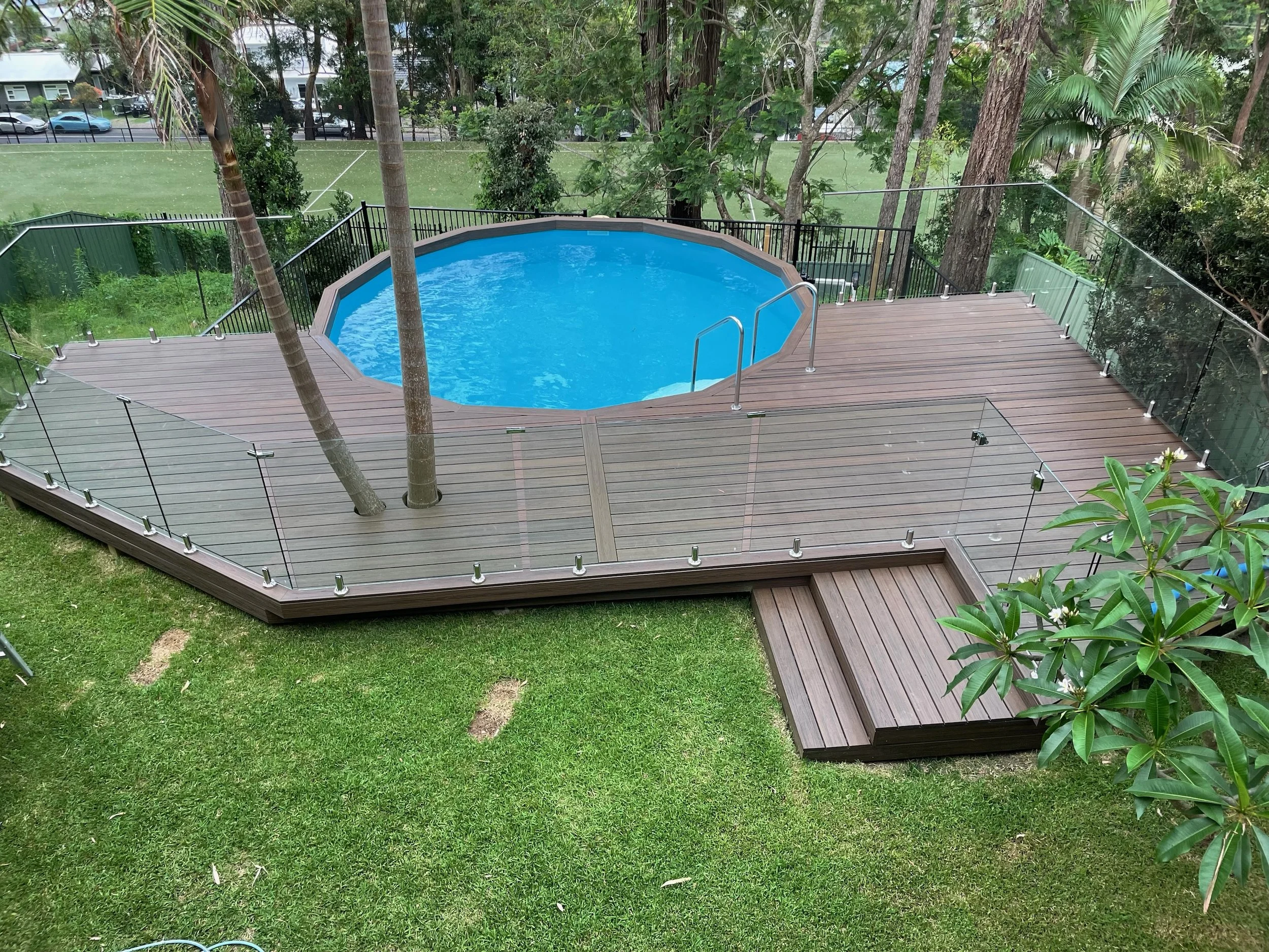 Backyard pool Trex Spiced Rum decking designed by Platinum Decks to blend tropical landscaping with refined outdoor architecture