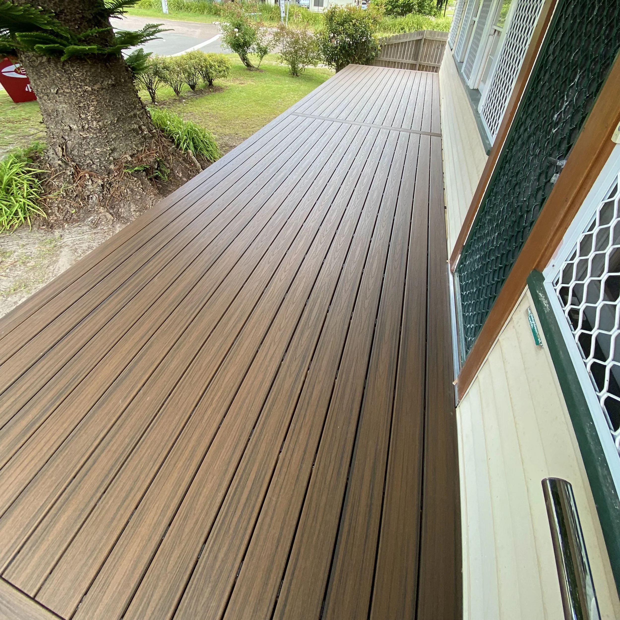 Trex composite deck in Havana gold overlooking garden and street frontage enhanced by Platinum Decks to create a warm, welcoming outdoor entry space