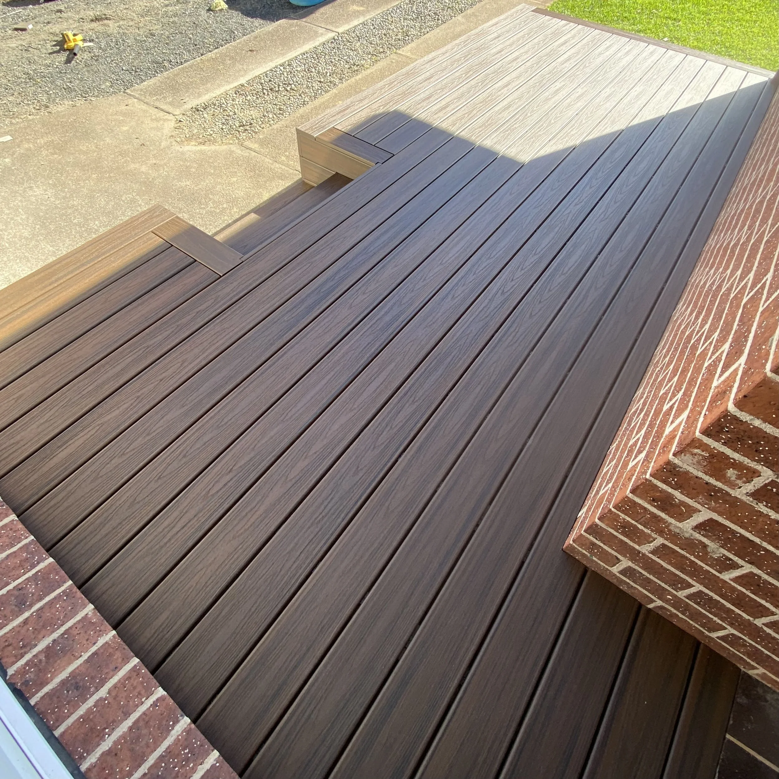 Trex deck in spiced rum beside a brick wall and concrete pavement