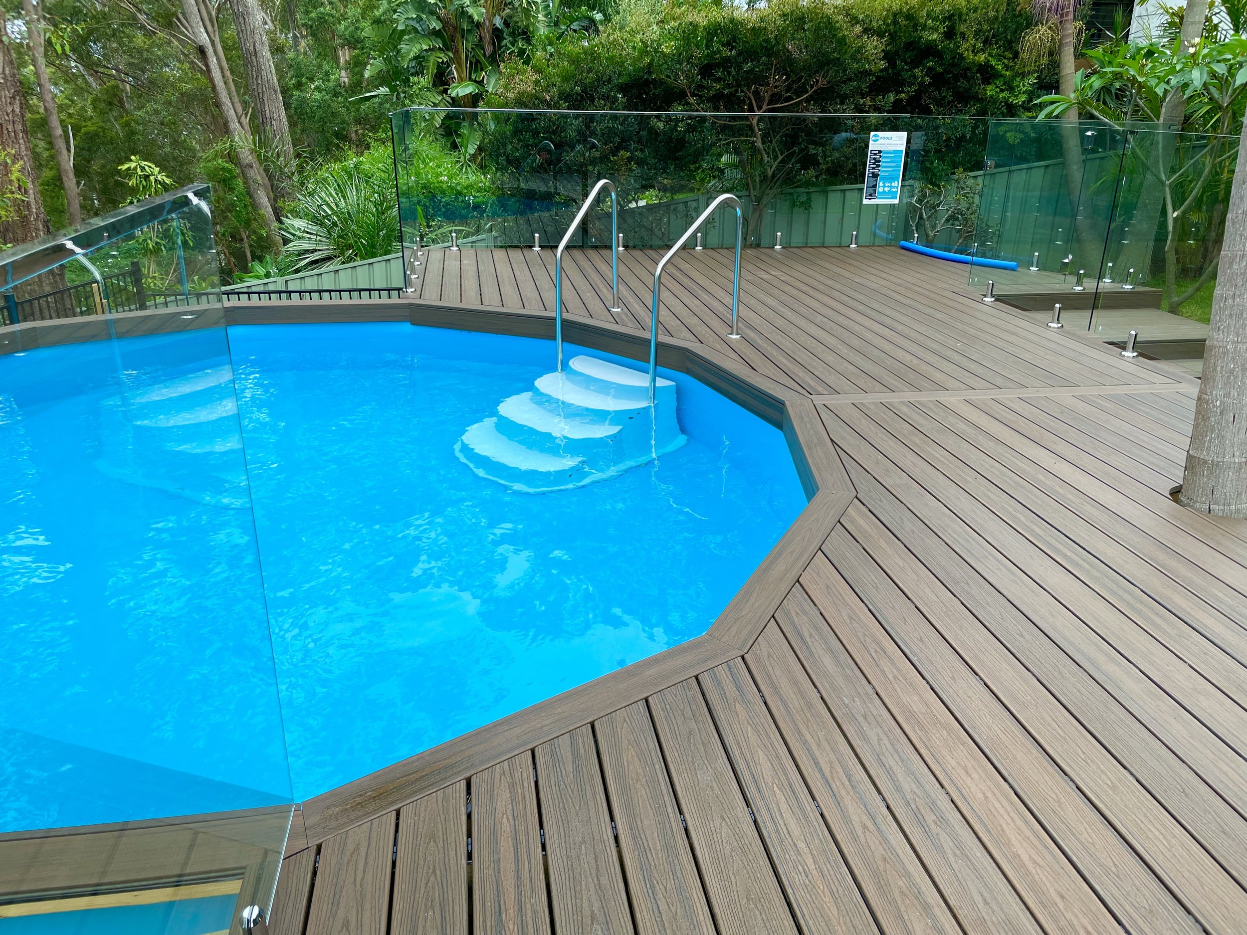 Backyard pool Trex Spiced Rum decking designed by Platinum Decks to blend tropical landscaping with refined outdoor architecture