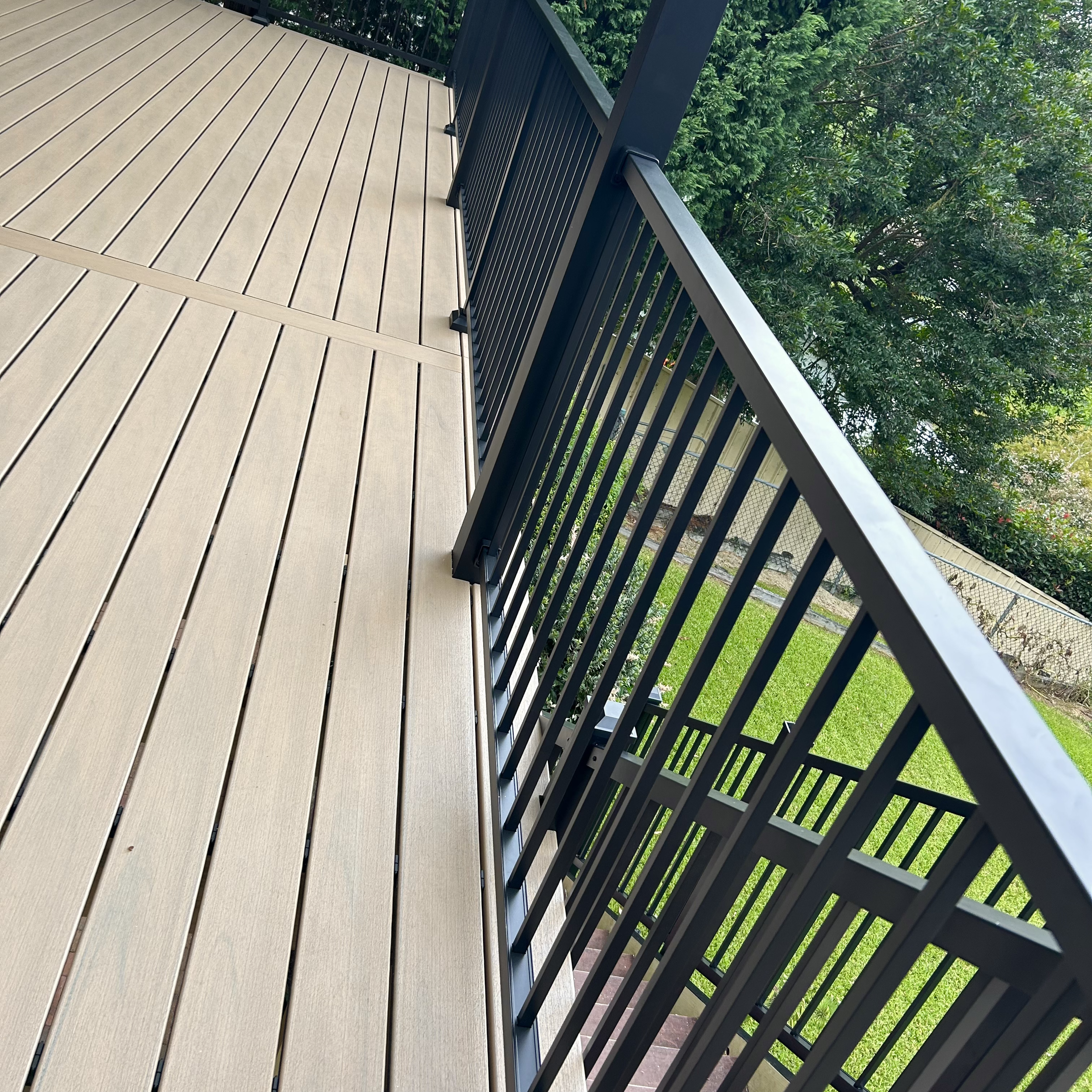Modern composite deck framed with architectural black railings installed by Platinum Decks to deliver a sleek, high‑end coastal look