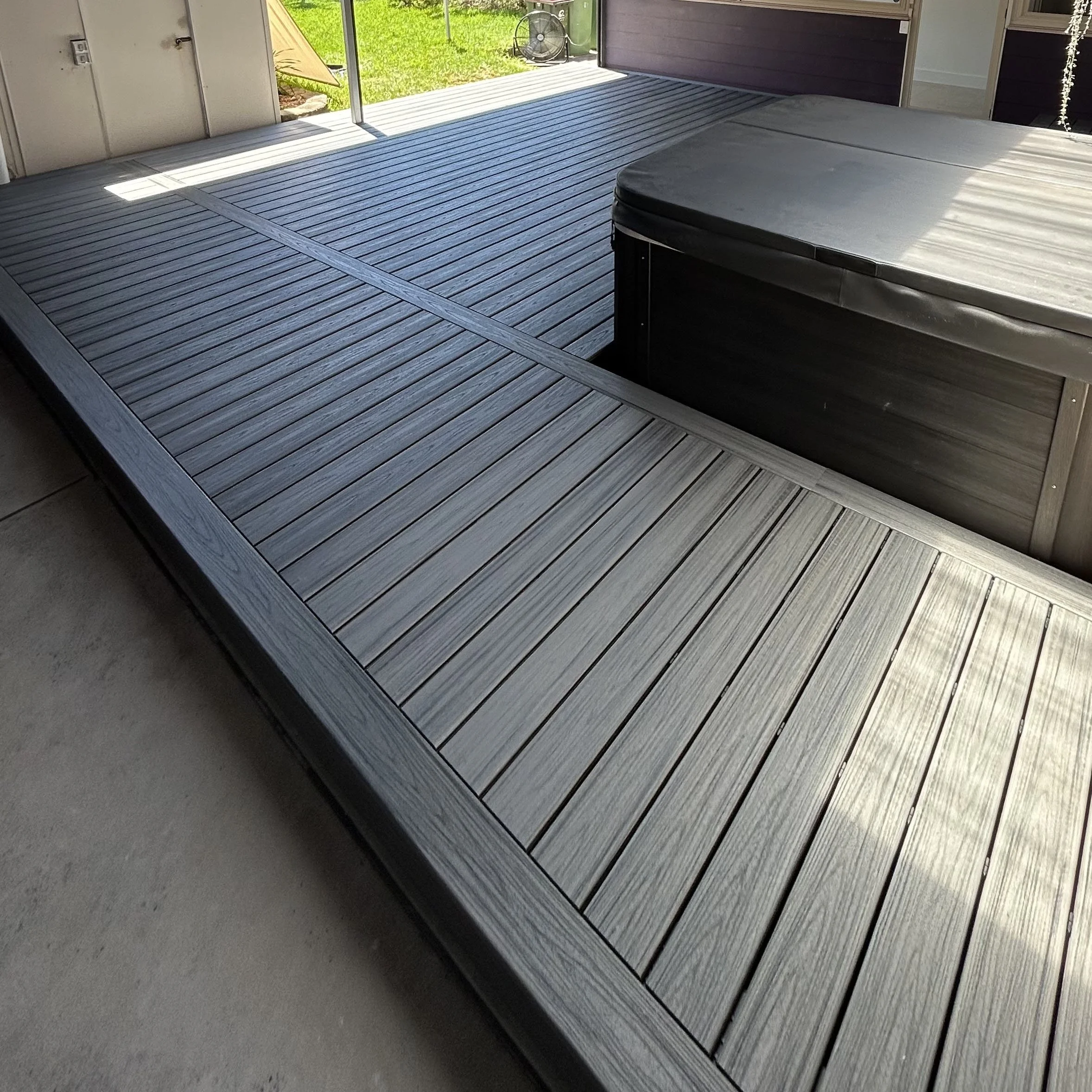 A composite spa deck built with grey boards to compliment the outdoor entertaining area. Built and designed by Platinum Decks.