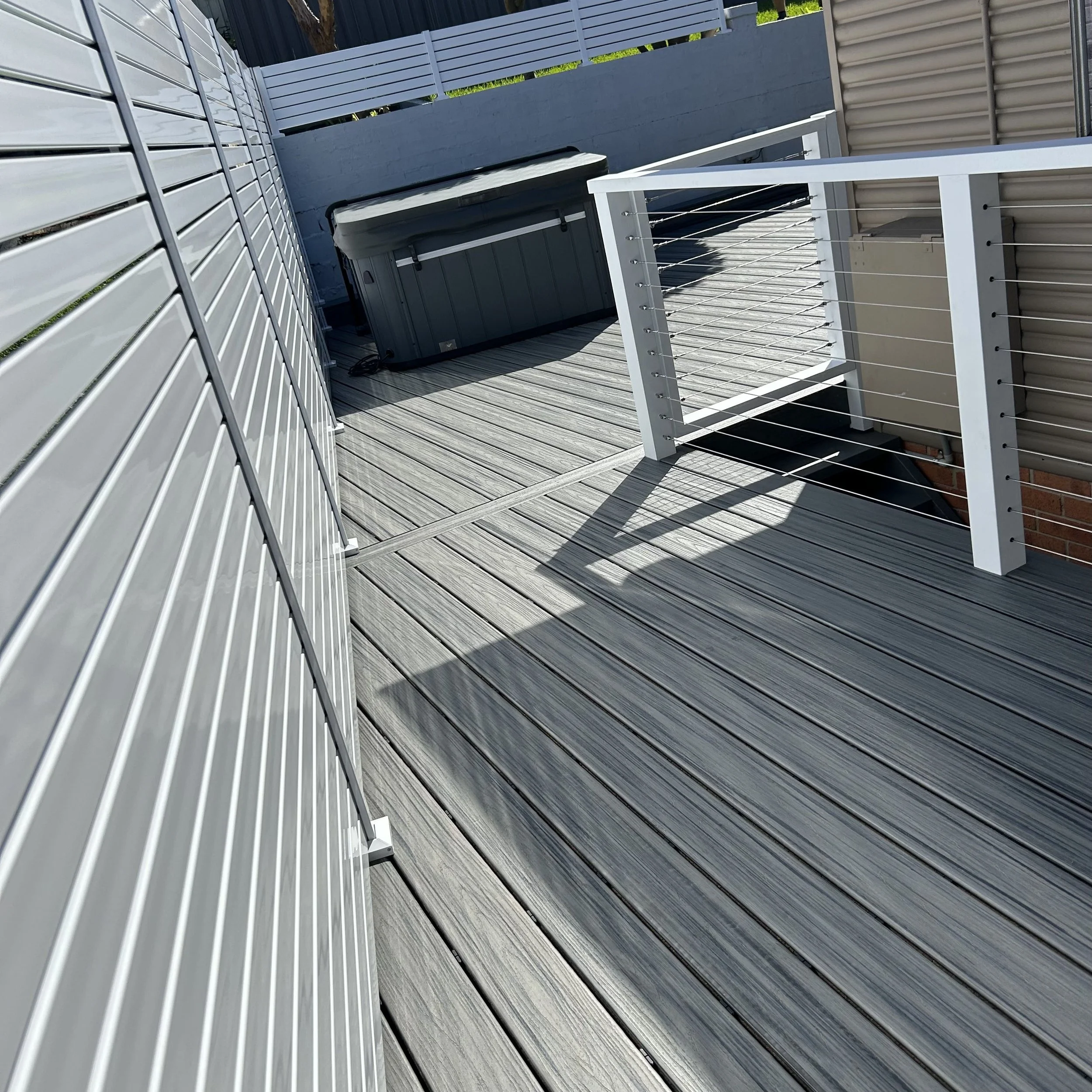 Premium composite deck with clean grey board layout elevated by Platinum Decks to deliver a refined, high‑end outdoor living experience