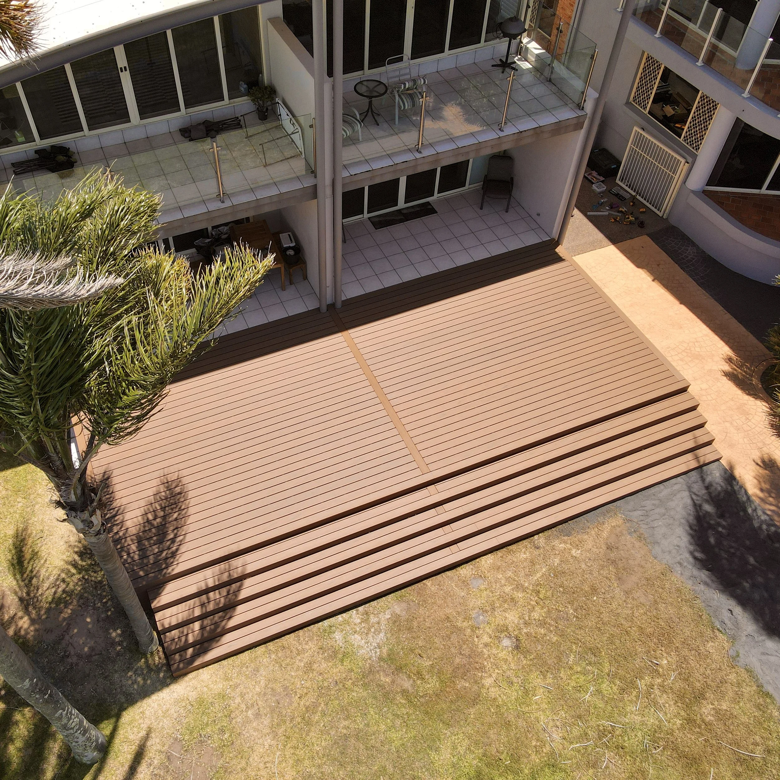 Trex deck in Jasper combining decking, tiles and landscaped greenery completed by Platinum Decks to showcase a luxury blend of textures and outdoor comfort
